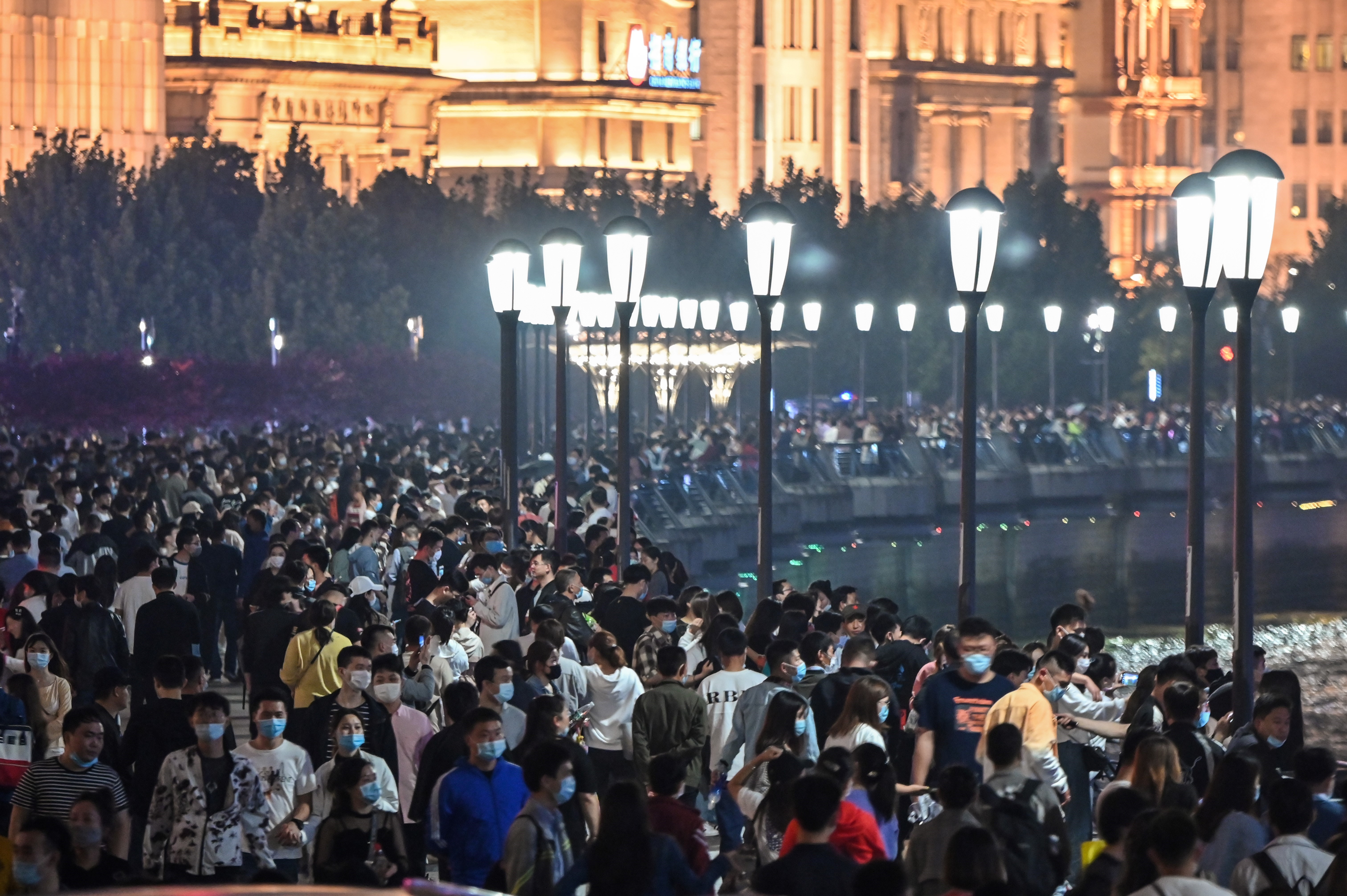 Large crowd of people wearing face masks visit the promenade on the Bund along the Huangpu River during a holiday on May Day, or International Workers' Day, in Shanghai on May 1.