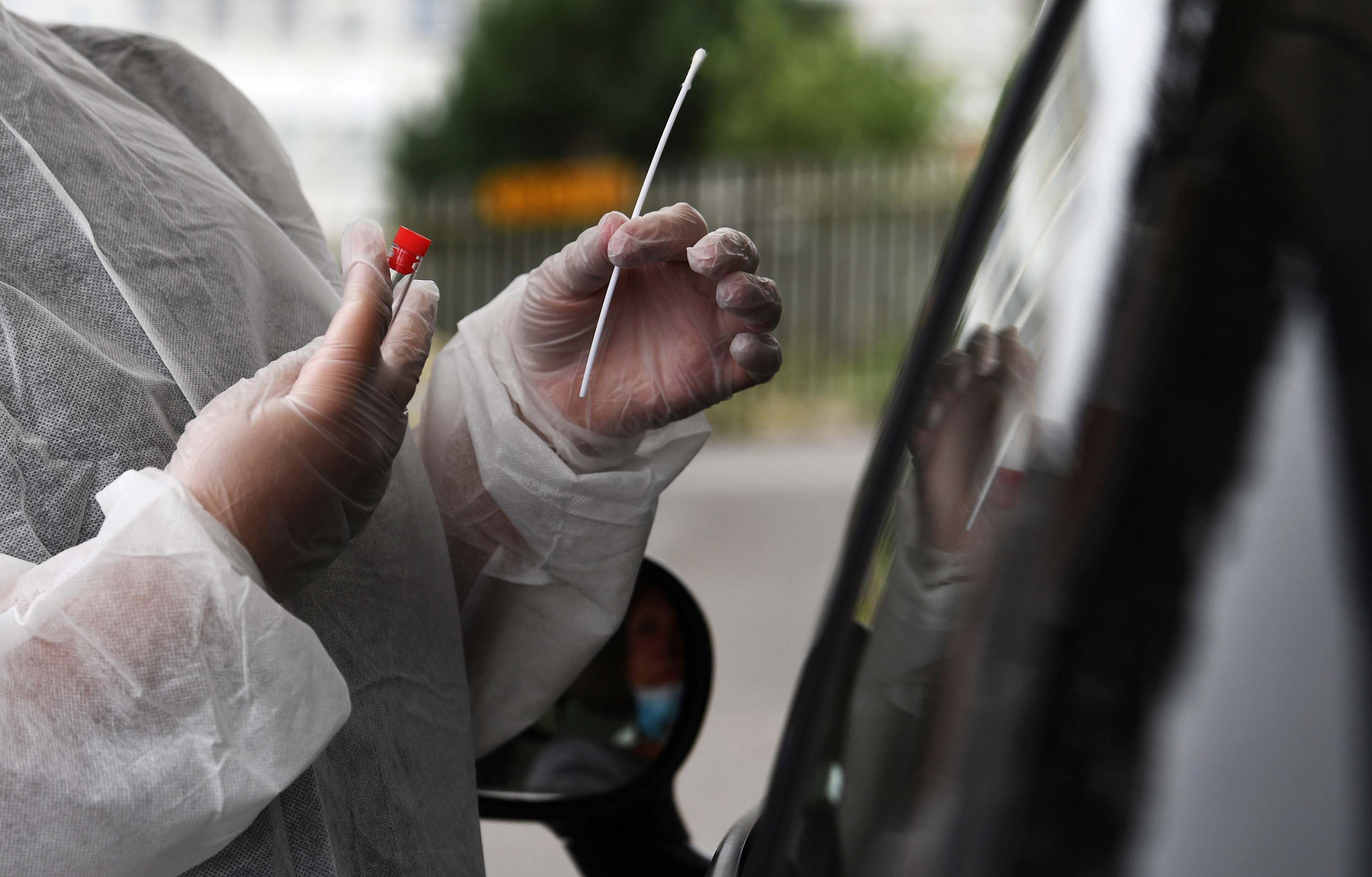 A medical worker collects a sample from a person at a Covid-19 drive-in testing center in Brest, France, on July 31.