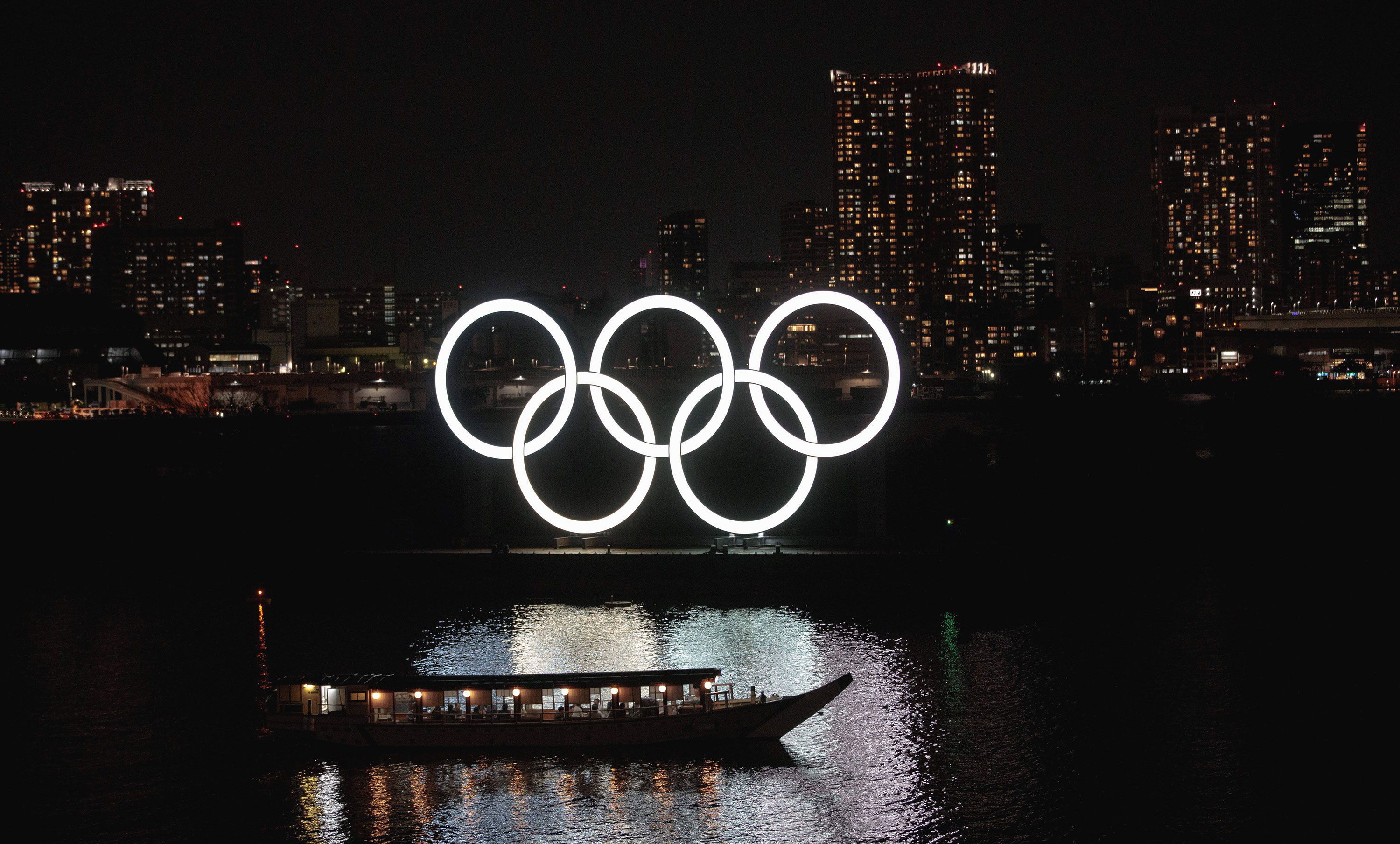 A boat passes by the Olympic rings in Tokyo's Odaiba district on March 23.