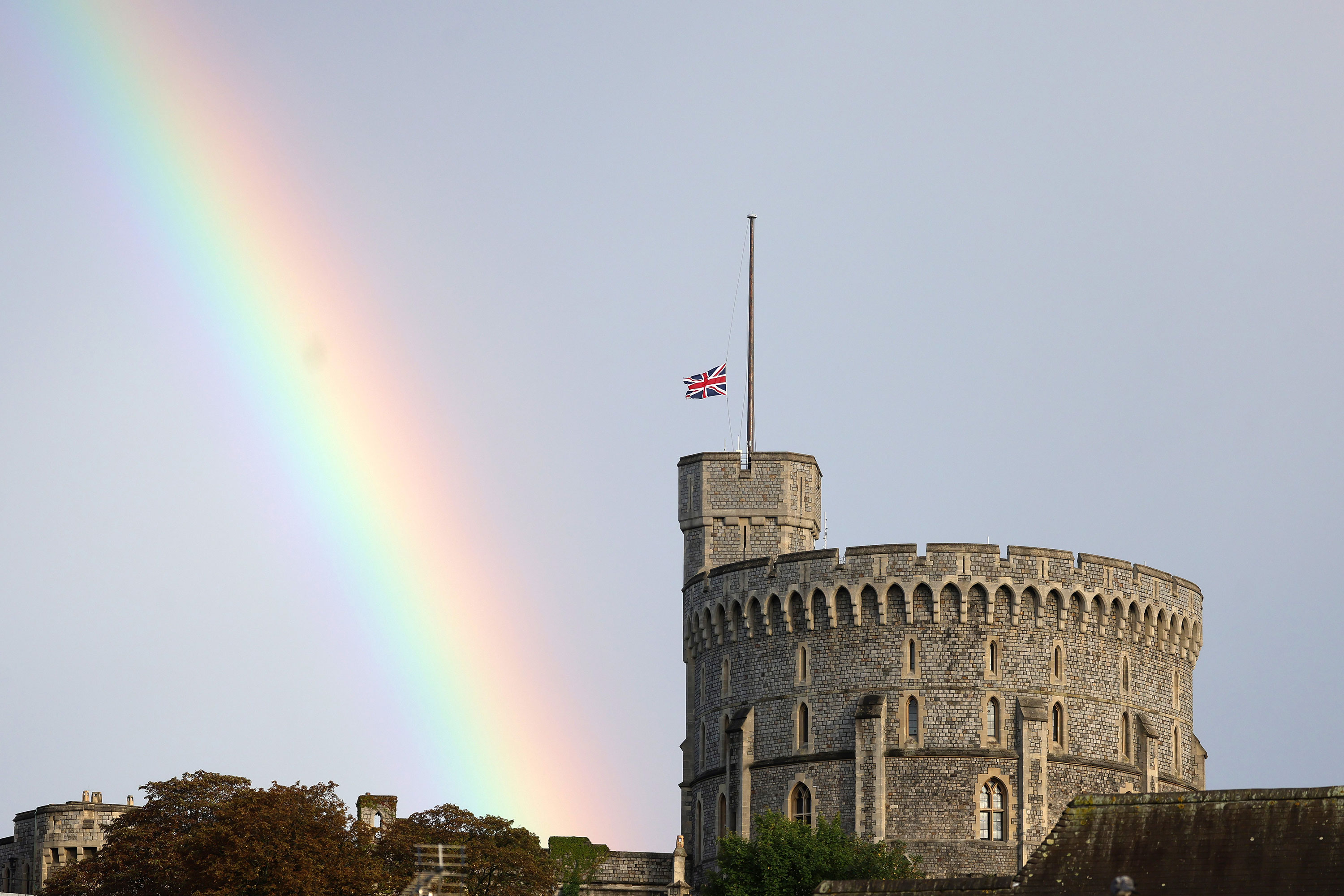 The Union flag is lowered at Windsor Castle as a rainbow covers the sky on Thursday.