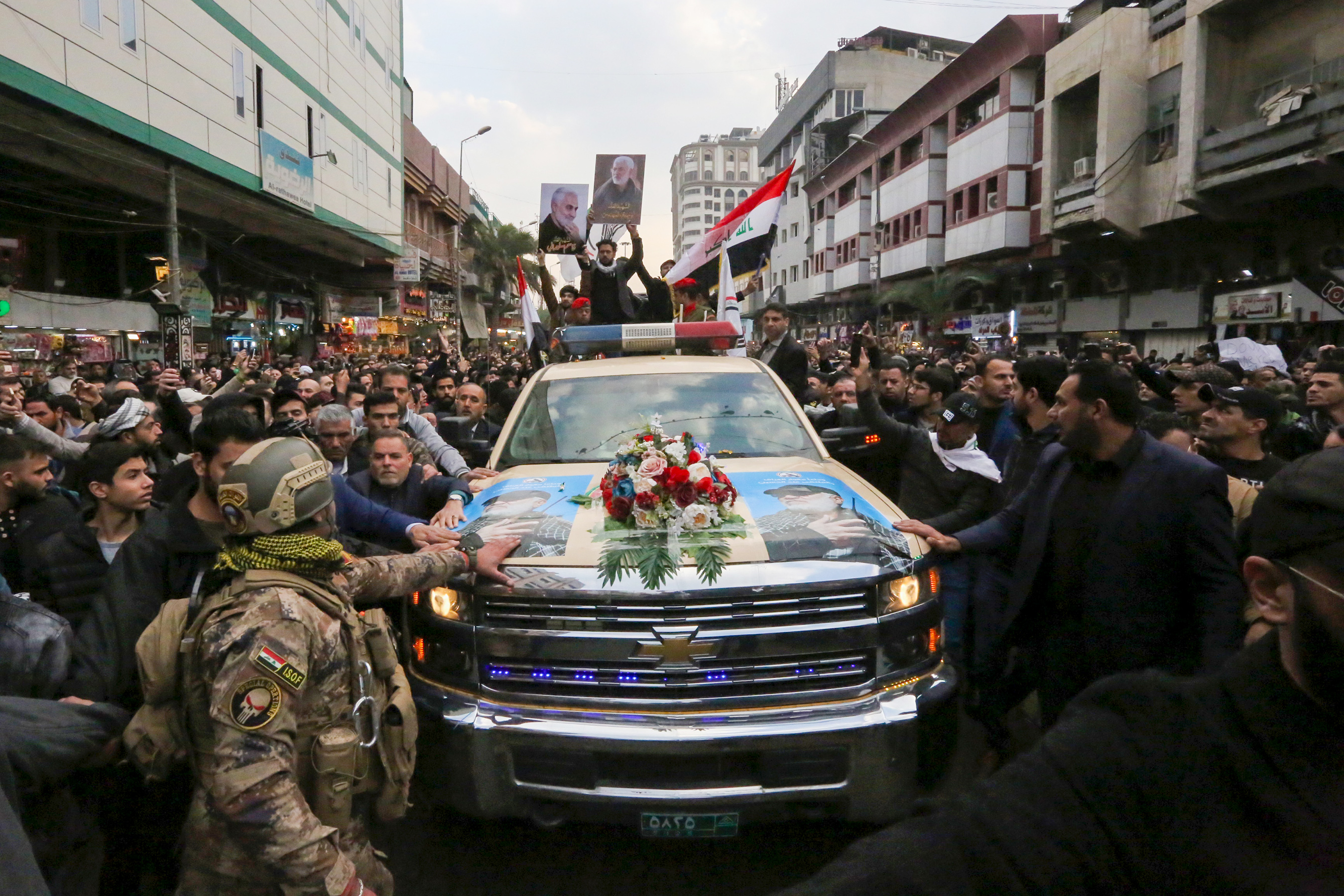 Mourners surround a car carrying the coffin of Iranian commander Qasem Soleimani in Baghdad, on January 4, 2020.