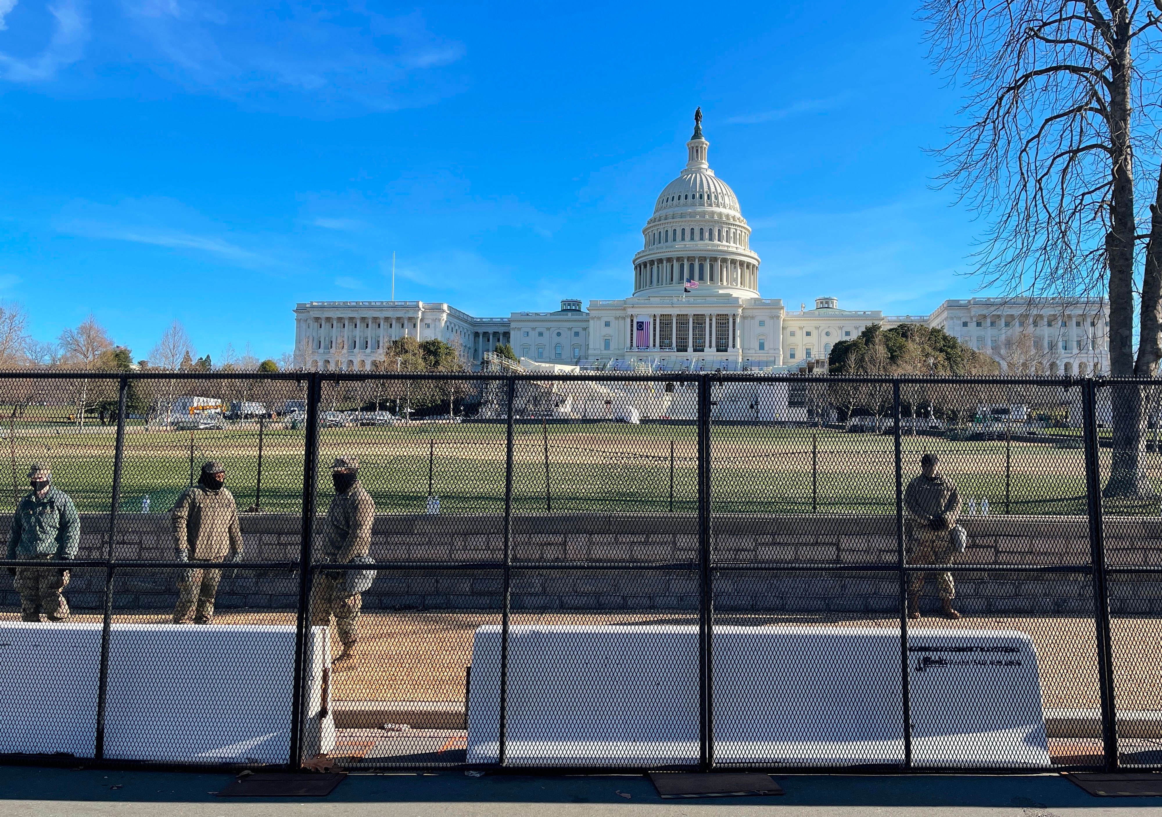 National Guard soldiers stand behind a security fence near the Capitol on January 9.