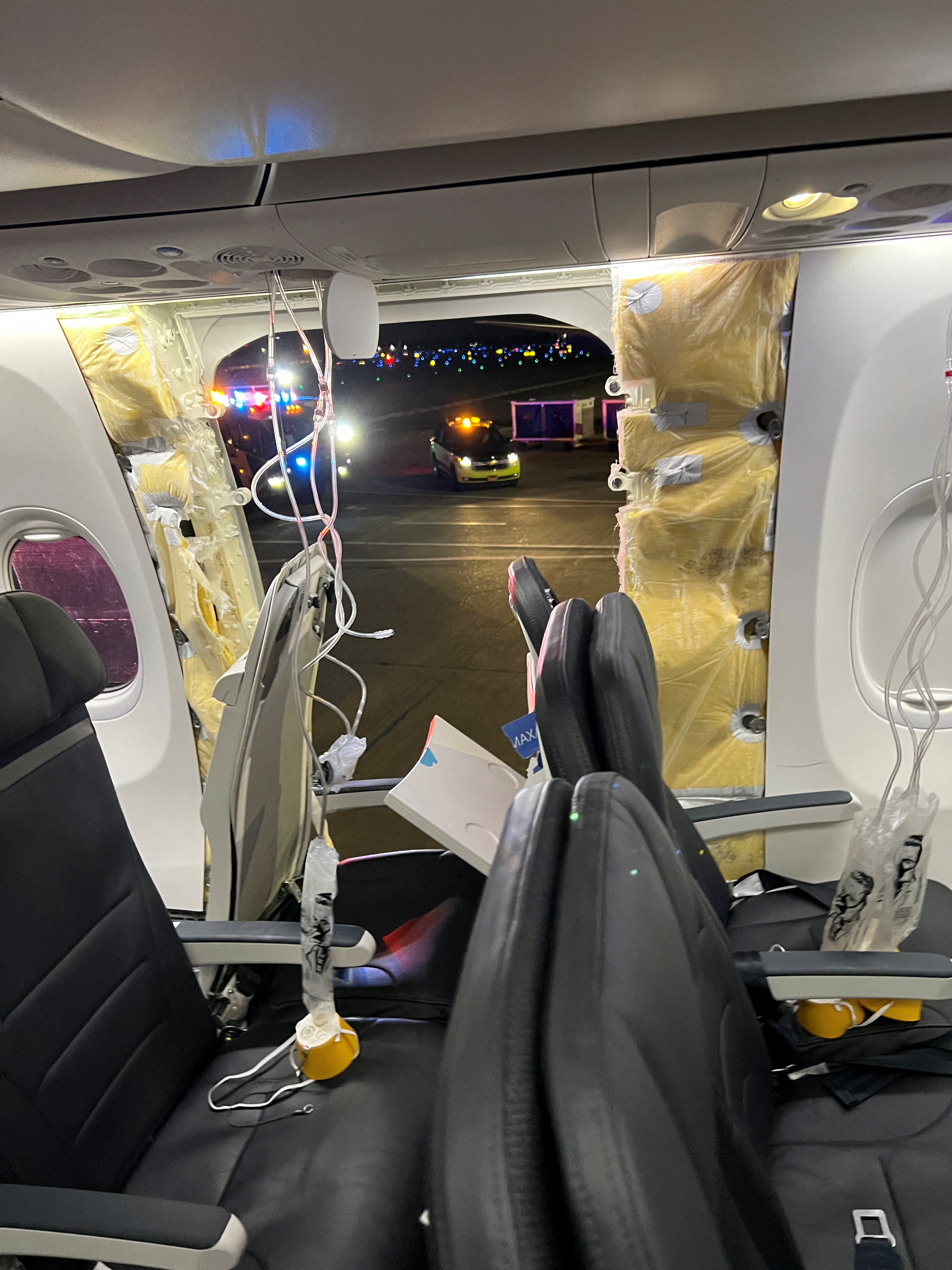 Passenger oxygen masks hang from the roof next to a missing panel of the fuselage on Alaska Airlines Flight 1282 in Portland, Oregon, on January 5.
