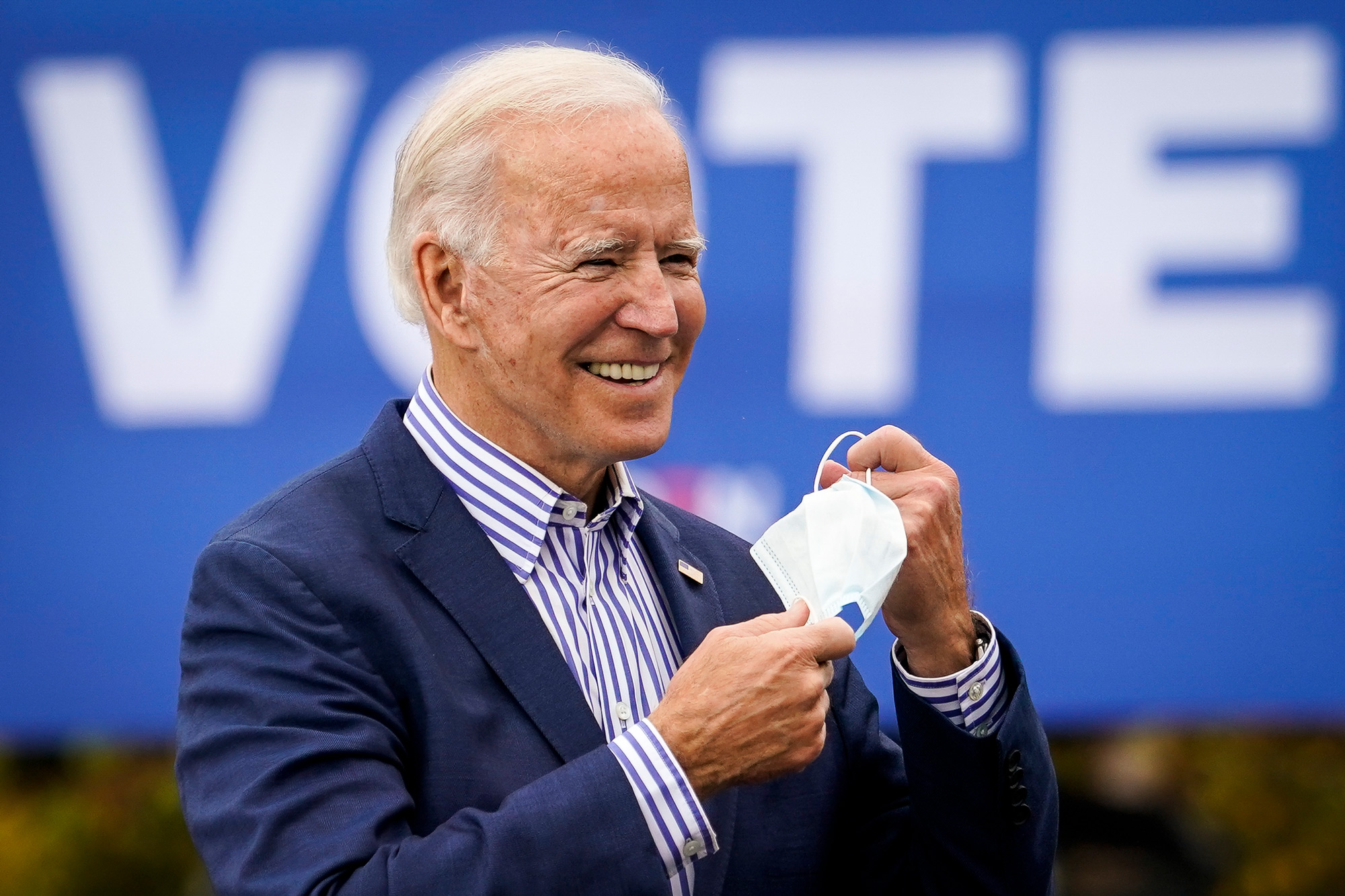 Democratic presidential nominee Joe Biden takes off his face mask to speak during a drive-in campaign rally at Bucks County Community College on October 24 in Bristol, Pennsylvania. 