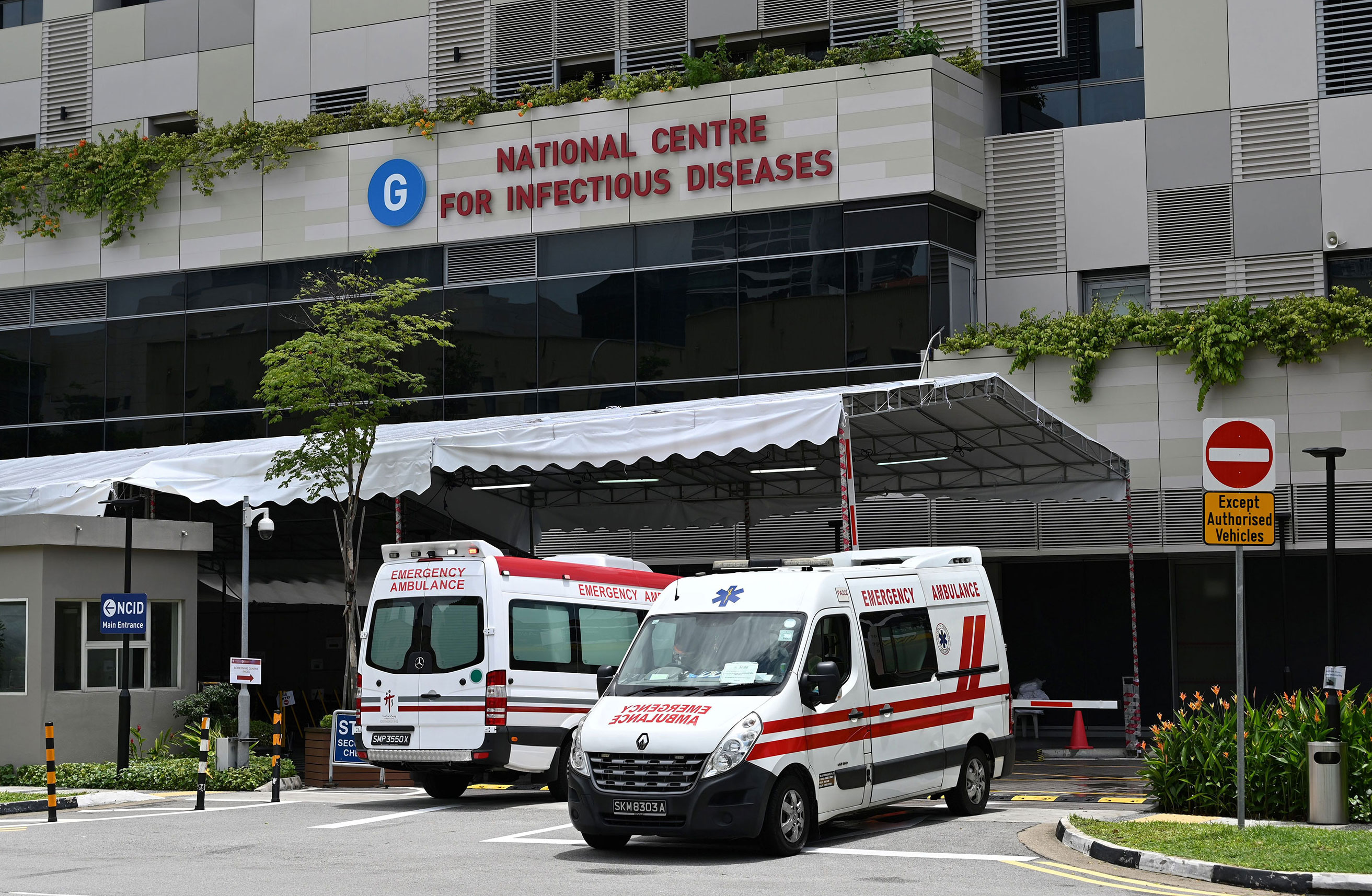 Ambulances sit in front of the National Center for Infectious Diseases, where coronavirus patients are being cared for, in Singapore on April 3.