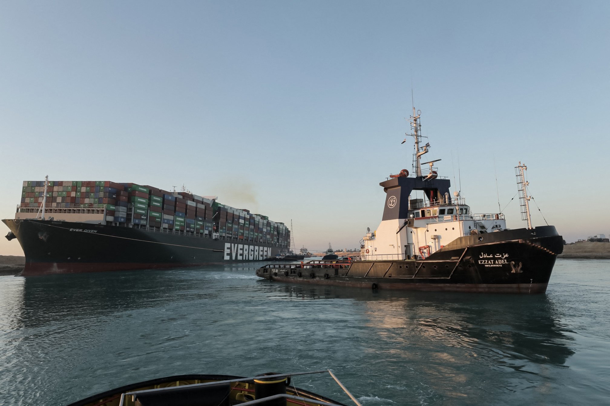 A handout picture released by the Suez Canal Authority on March 29, 2021, shows tugboats pulling the Panama-flagged MV 'Ever Given' container ship lodged sideways impeding traffic across Egypt's Suez Canal waterway. 