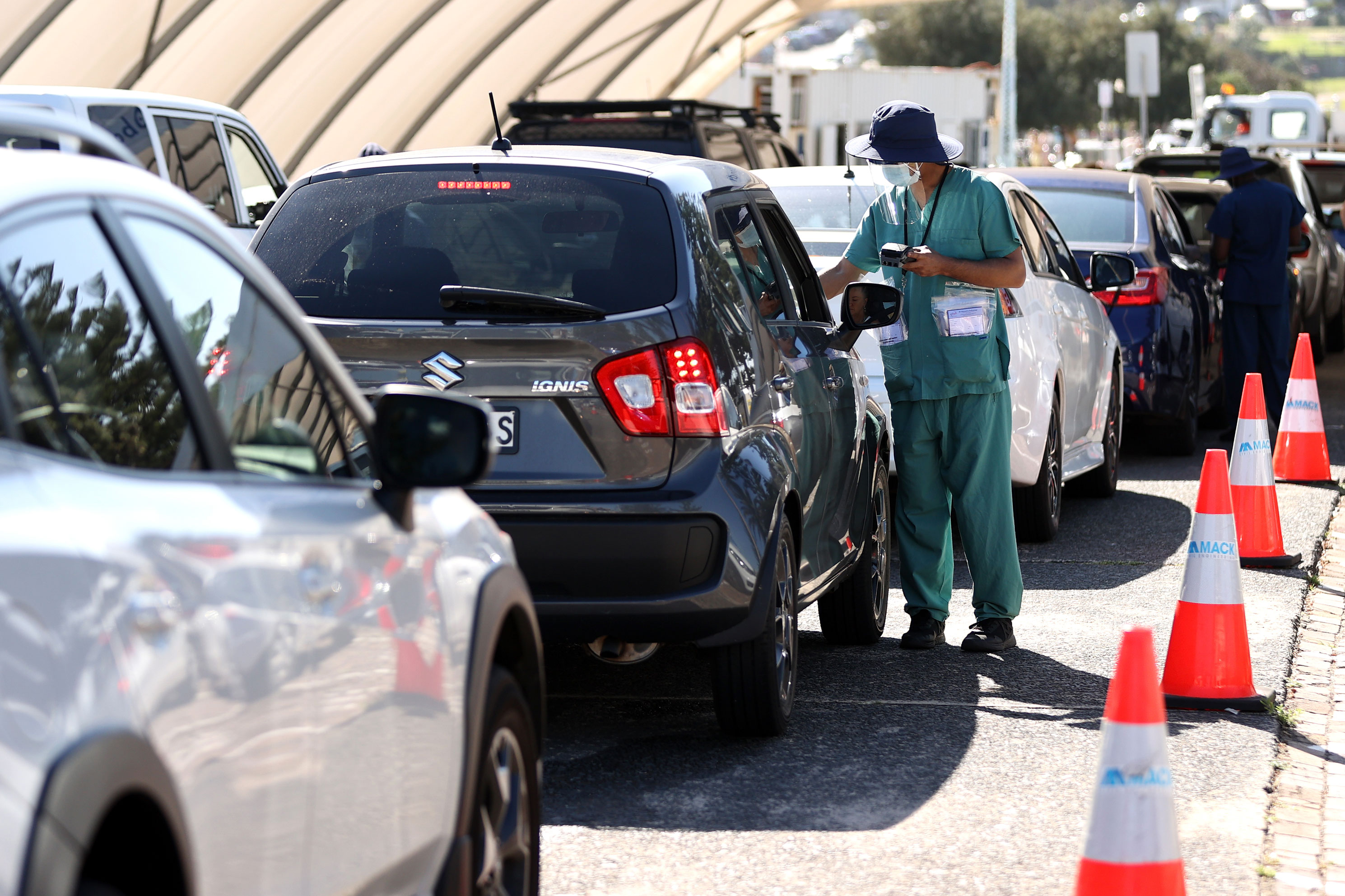 A worker speaks to people queued inside their cars at the St.Vincent's Bondi Covid-19 testing center on December 21, 2021 in Sydney, Australia. 
