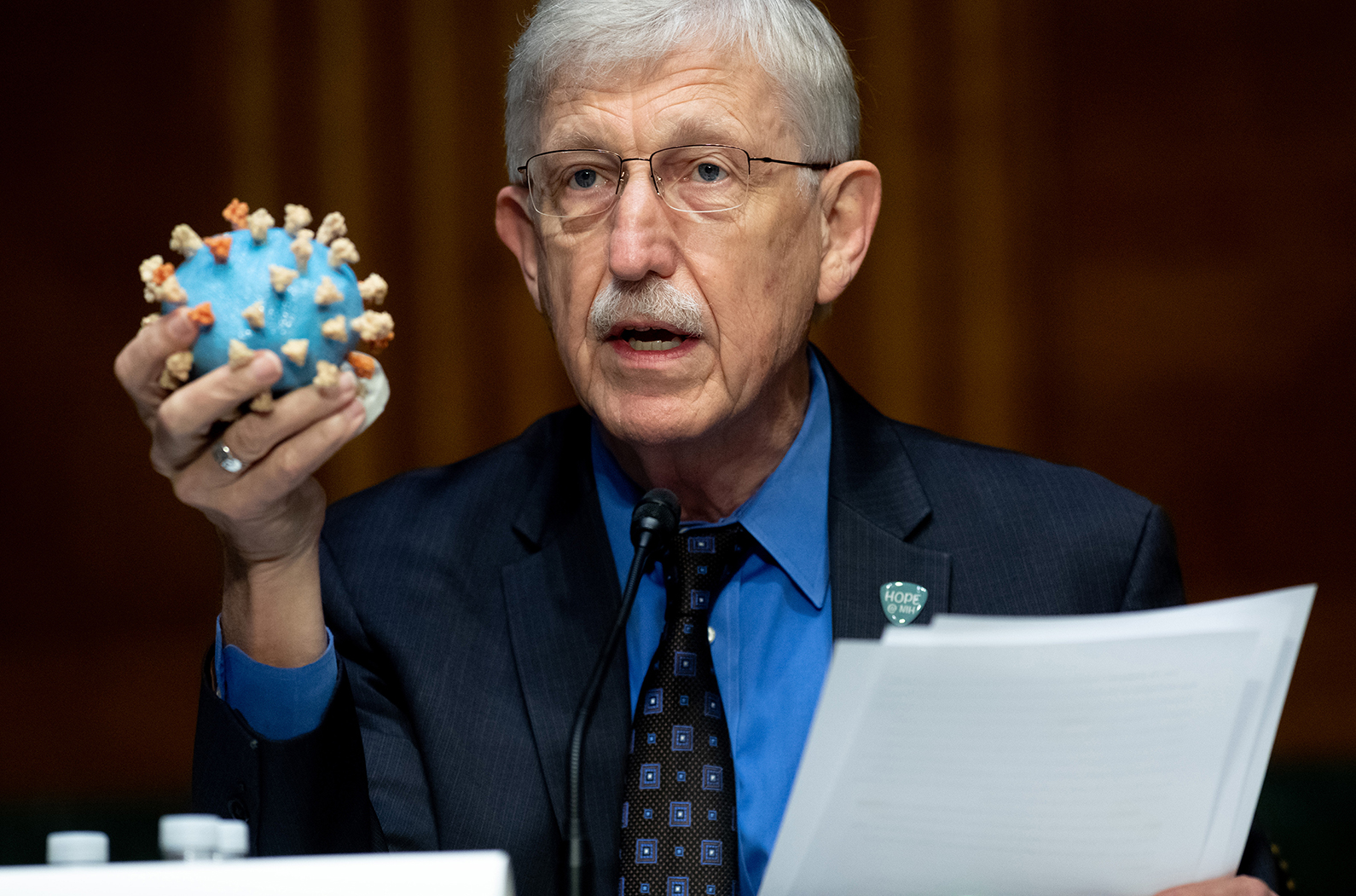 Dr. Francis Collins, Director of the National Institutes of Health (NIH), holds up a model of COVID-19, known as coronavirus, during a US Senate Appropriations subcommittee hearing on the plan to research, manufacture and distribute a coronavirus vaccine, known as Operation Warp Speed, July 2, 2020 on Capitol Hill in Washington, DC. 