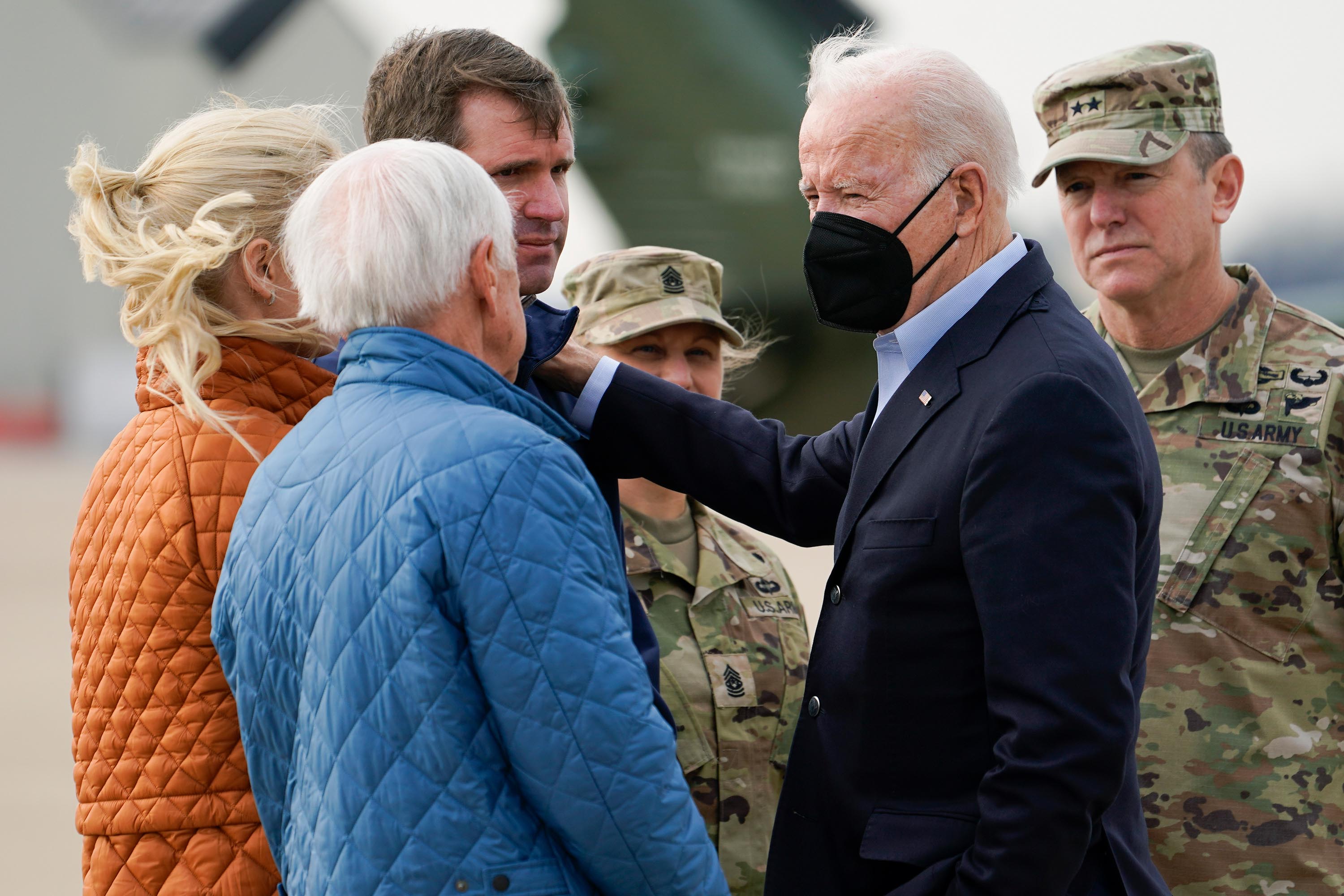President Joe Biden greets Kentucky Gov. Andy Beshear and his wife Britainy Beshear, left, and former Gov. Steve Beshear, second from left, as he arrives in Fort Campbell, Kentucky, on December 15 to survey storm damage from tornadoes and extreme weather.