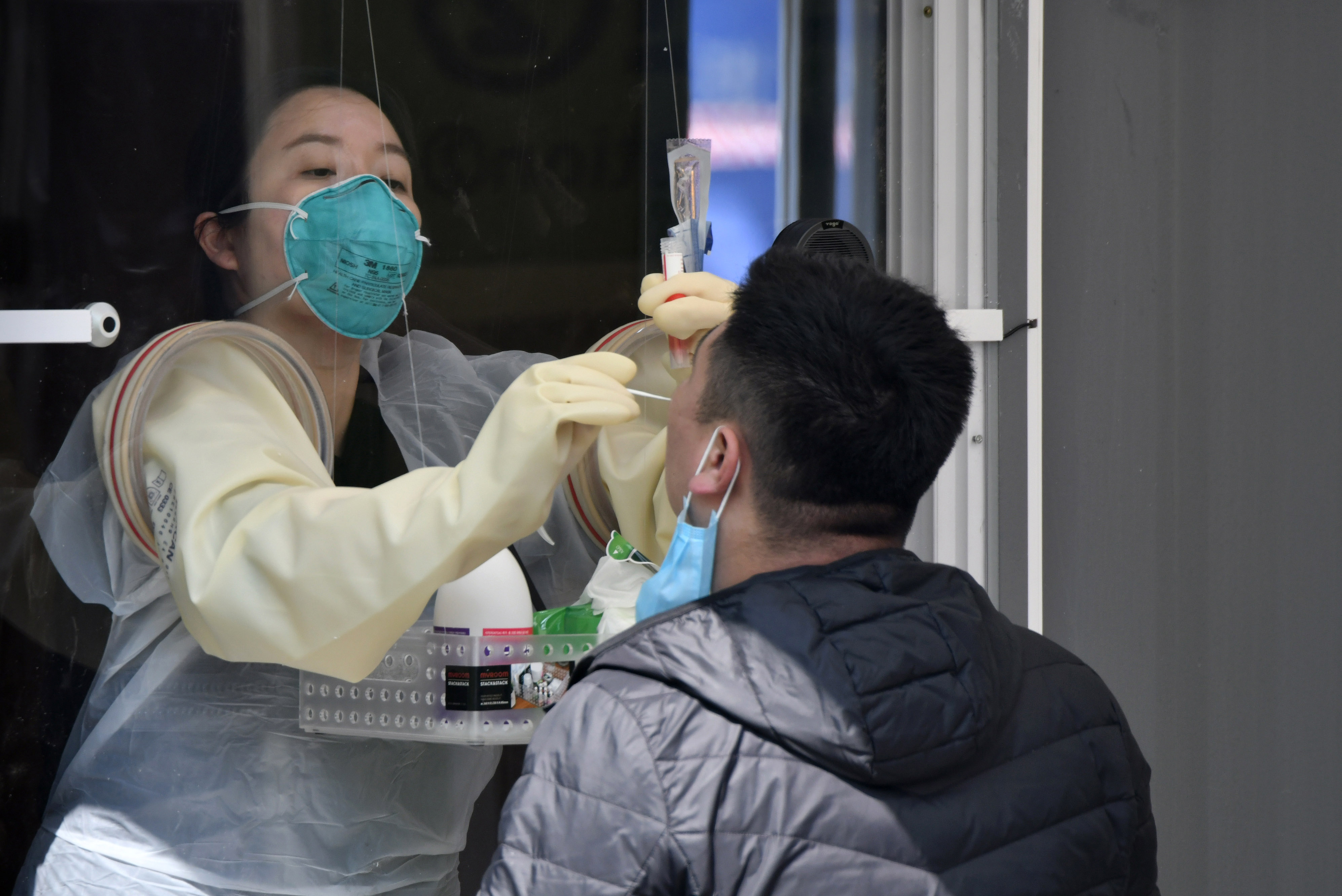 A medical staff member takes samples from a man at a walk-thru Covid-19 testing station set up at Jamsil Sports Complex in Seoul, South Korea, on April 3.