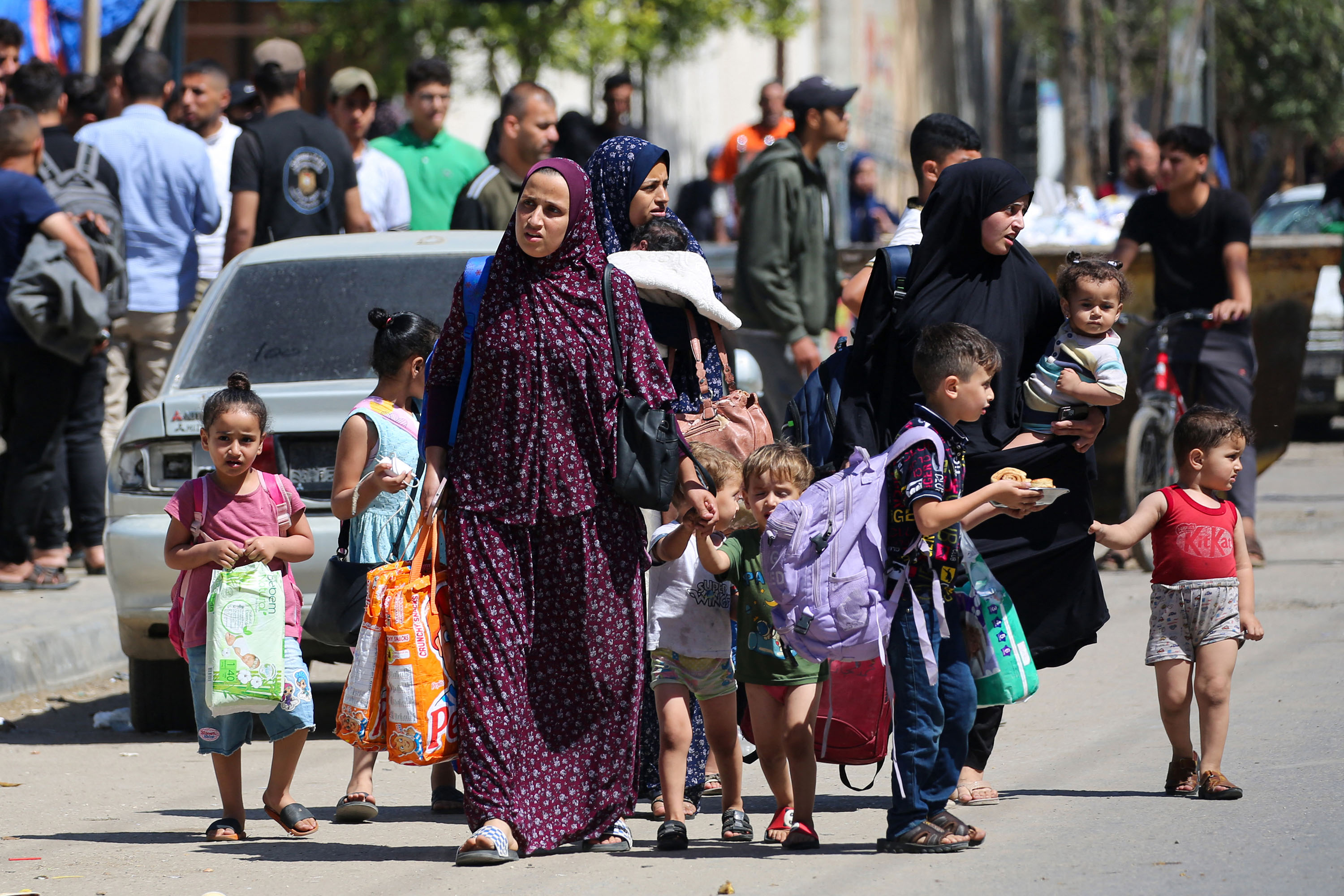 Women and children carry their belongings as they flee Rafah on May 15.