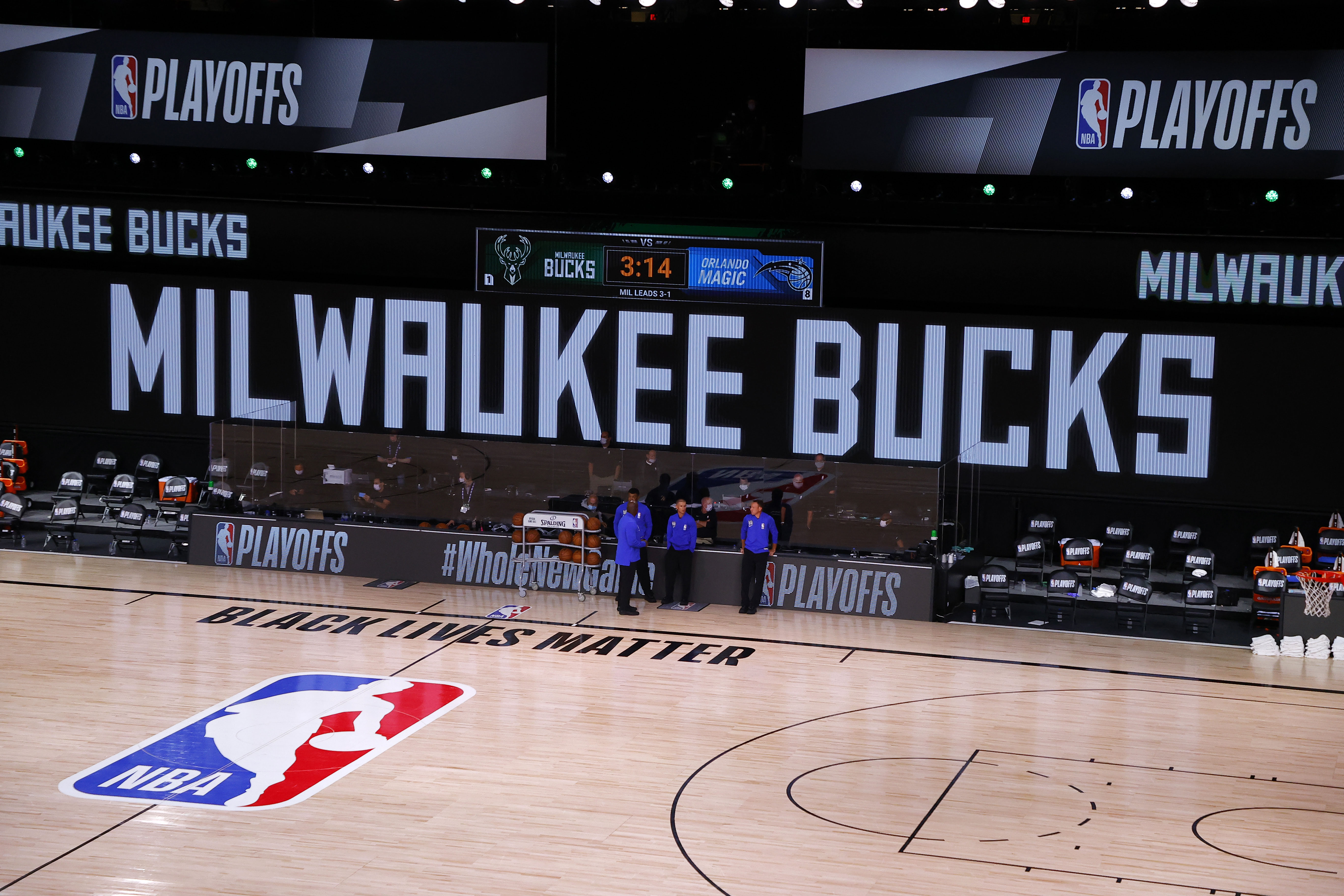 Referees stand on an empty court before the start of what would have been a game between the Milwaukee Bucks and the Orlando Magic in Lake Buena Vista, Florida, on August 26. The Milwaukee Bucks boycotted the playoff game following the police shooting of Jacob Blake.