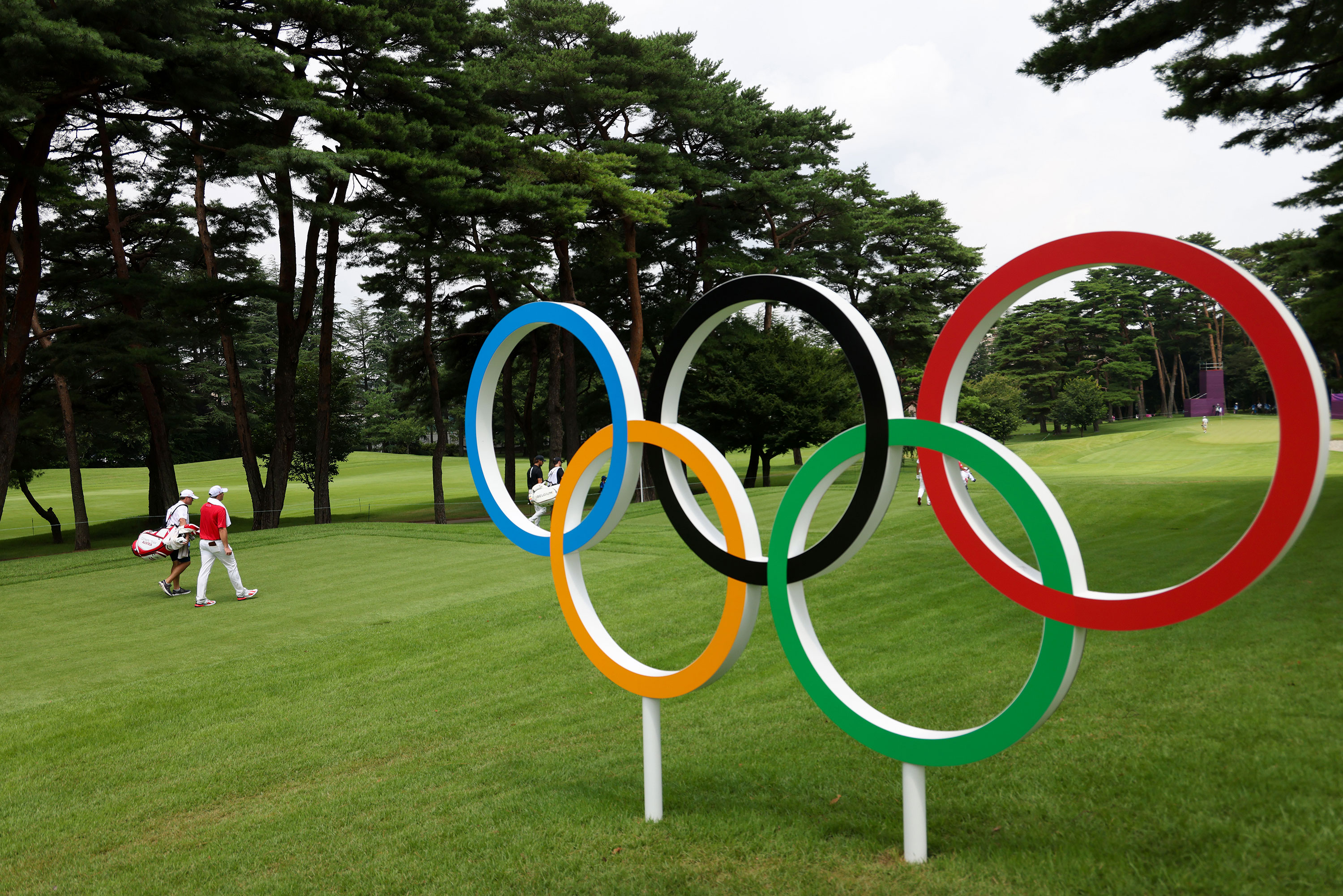Australia's Sepp Straka and his younger brother Samuel Straka walk past the Olympic rings on the 16th hole in the first round of the individual stroke event in Kawagoe, Japan on July 29.
