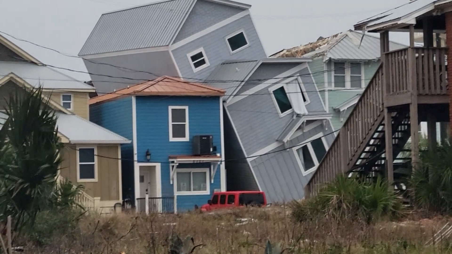 A house is seen teetering on its side in the Grand Lagoon area of Panama City, Florida, as severe weather, including tornadoes, passed through the Florida panhandle on Tuesday morning. 