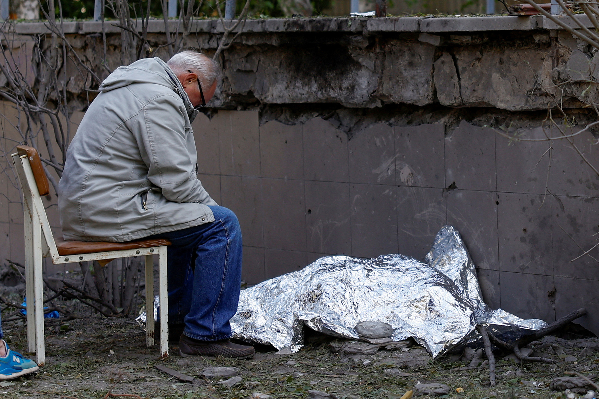 A man sits next to the body of his granddaughter who was killed during a Russian missile strike in Kyiv, Ukraine, on June 1.