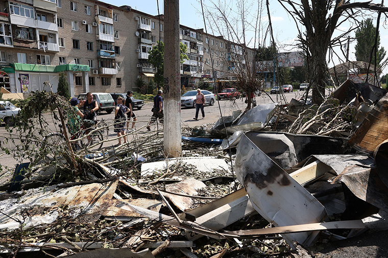 People stand in front of a destroyed market after a Russian missile strike in the town of Bakhmut, Donetsk region on July 16.