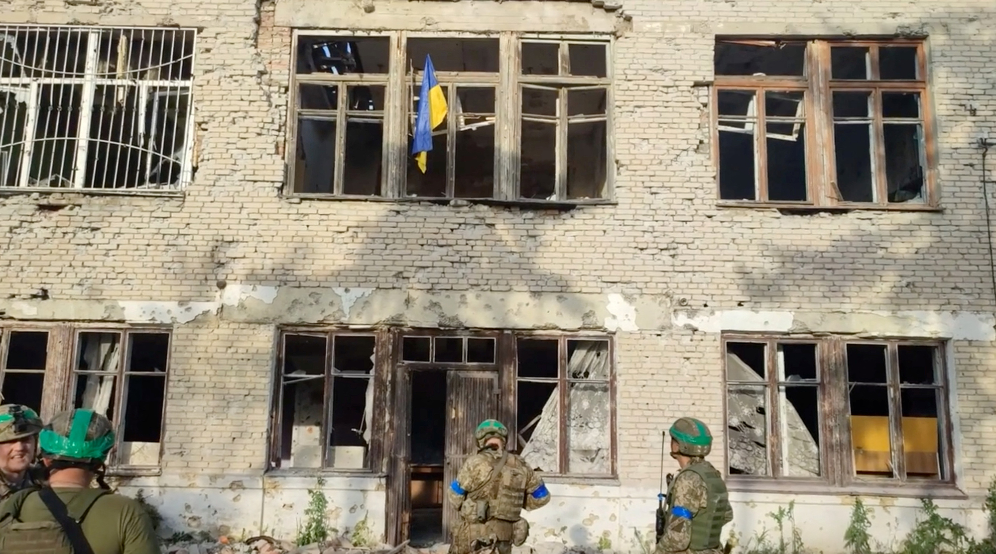 Ukrainian soldiers stand in front of a building with a Ukrainian flag, during an operation that claims to liberate the village of Blahodatne, in this screengrab taken from a handout video released on June 11. 