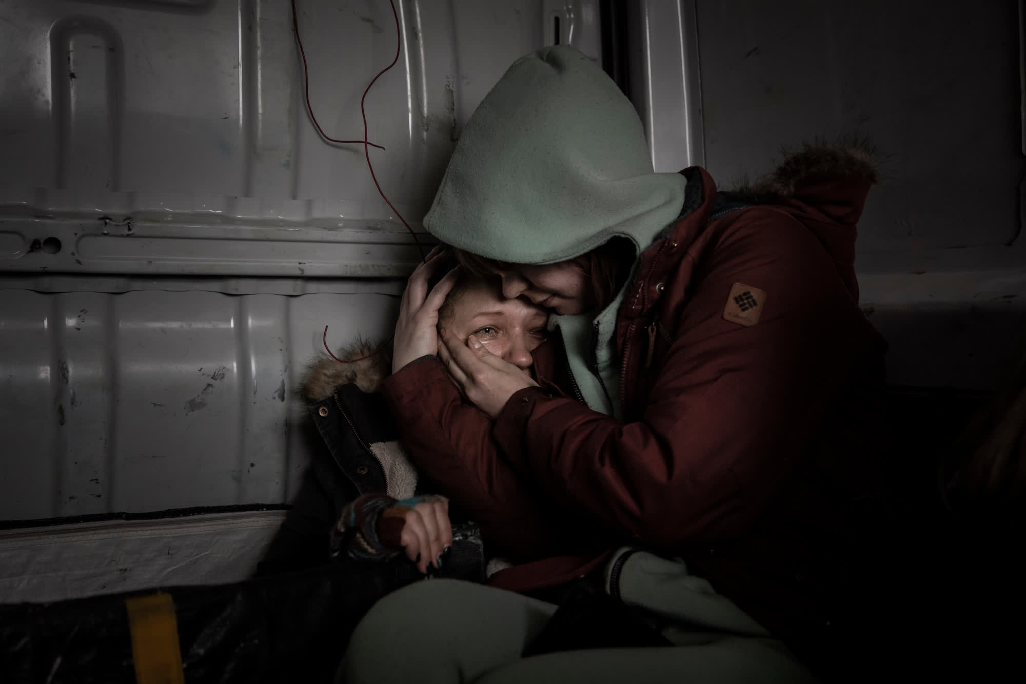 A woman is comforted inside a van during the evacuation of Irpin, Ukraine, in March 2022. Irpin, a suburb of capital city Kyiv, was under attack by Russian artillery. It saw weeks of fighting in the early days of the war.