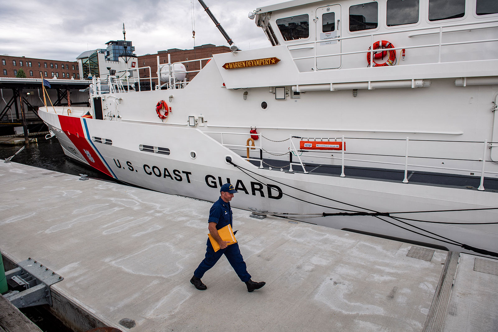 A member of the Coast Guard walks by a Coast Guard Cutter in Boston on June 20. 