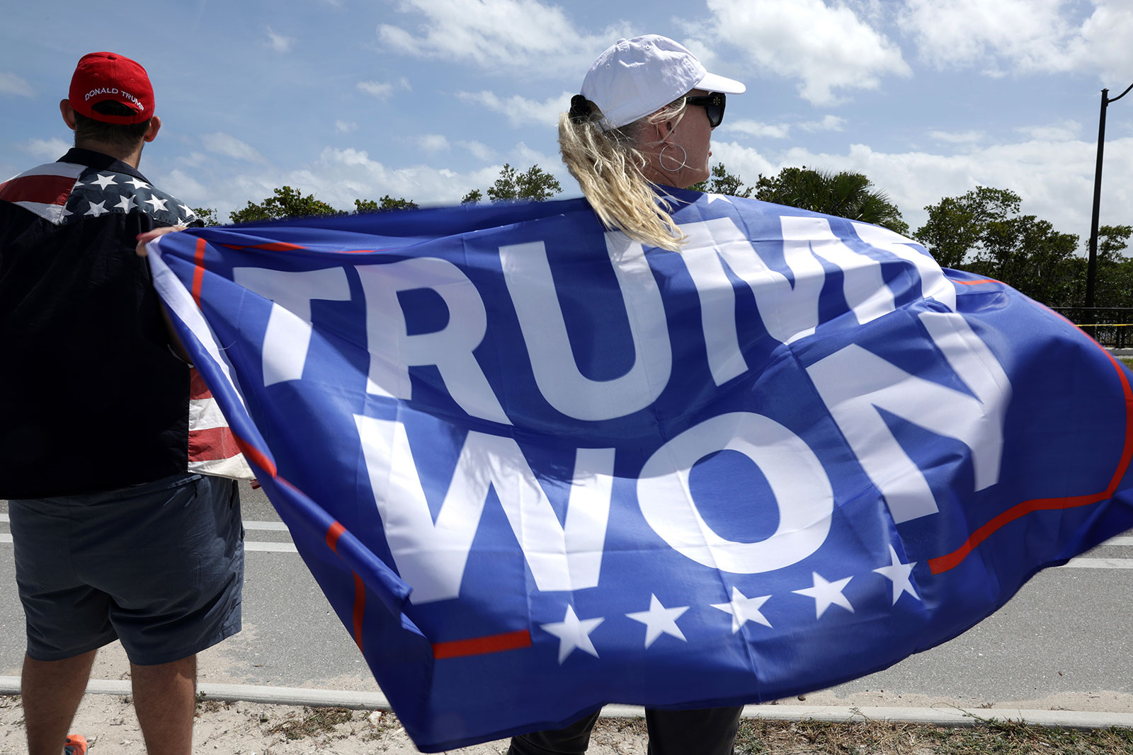 A supporter of former US President Donald Trump holds a flag that read "Trump Won" to show support near his Mar-a-Lago home on March 31 in Palm Beach, Florida.
