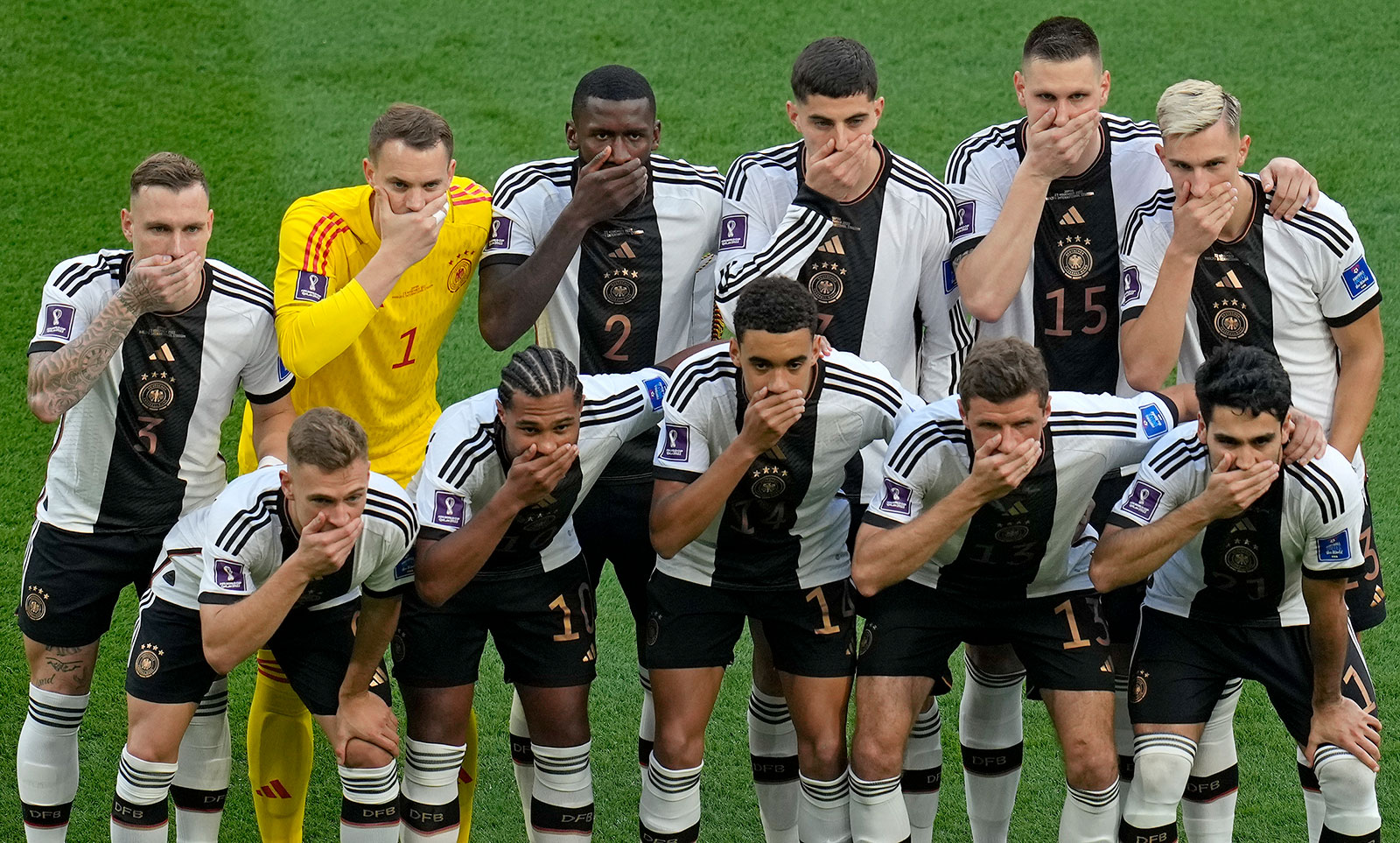 Germany's soccer team players cover their mouths as they pose for a group photo before the match against Japan on November 23. 