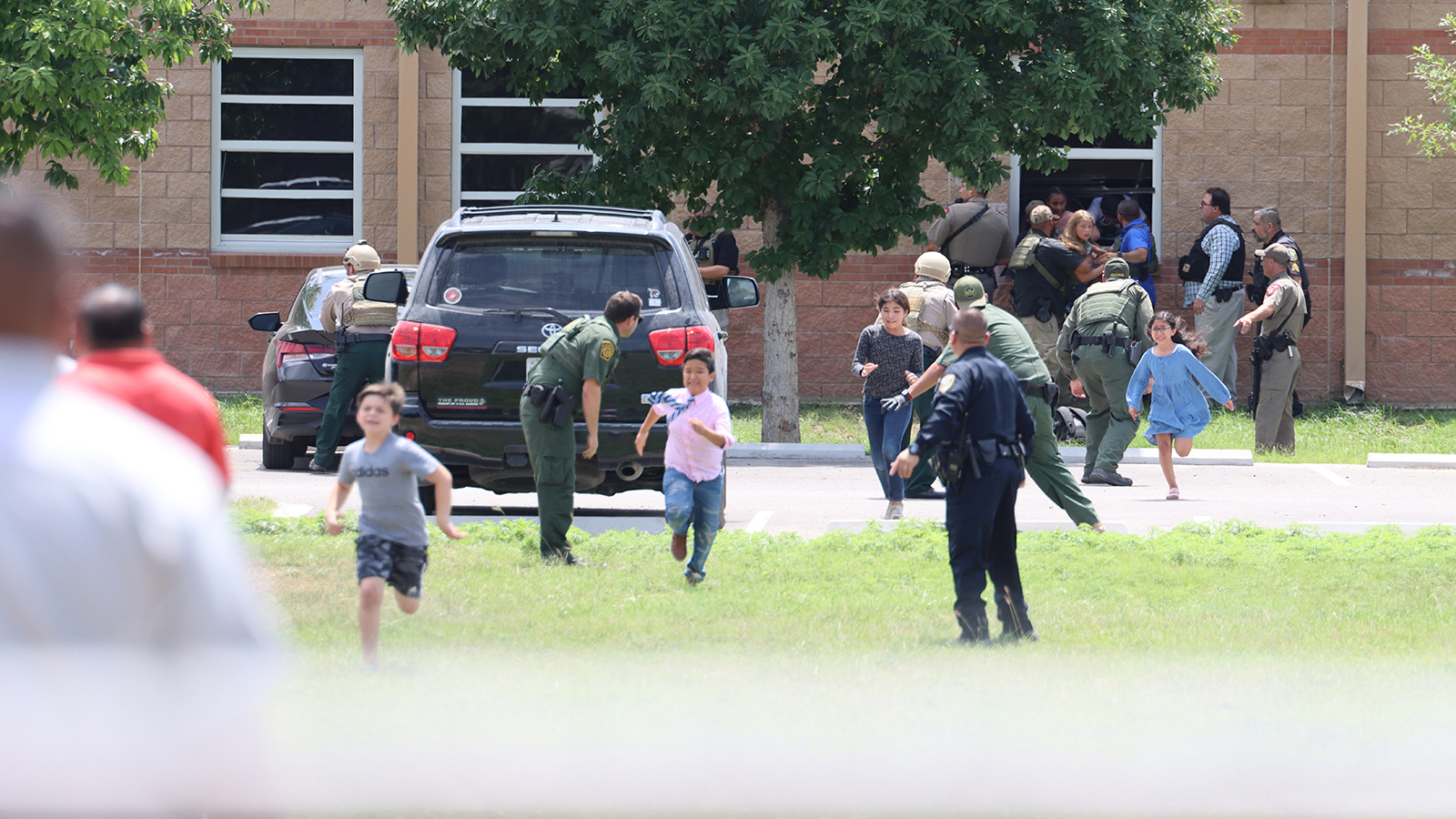 Students run to safety after escaping from a window at Robb Elementary School on May 24.