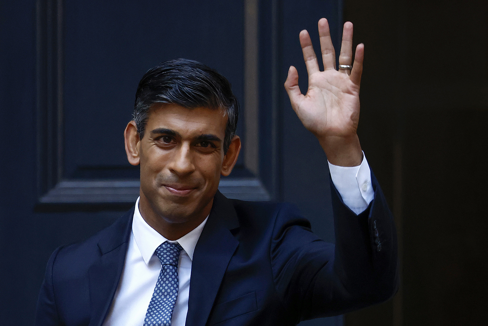 Rishi Sunak waves as he departs Conservative Party Headquarters today in London.