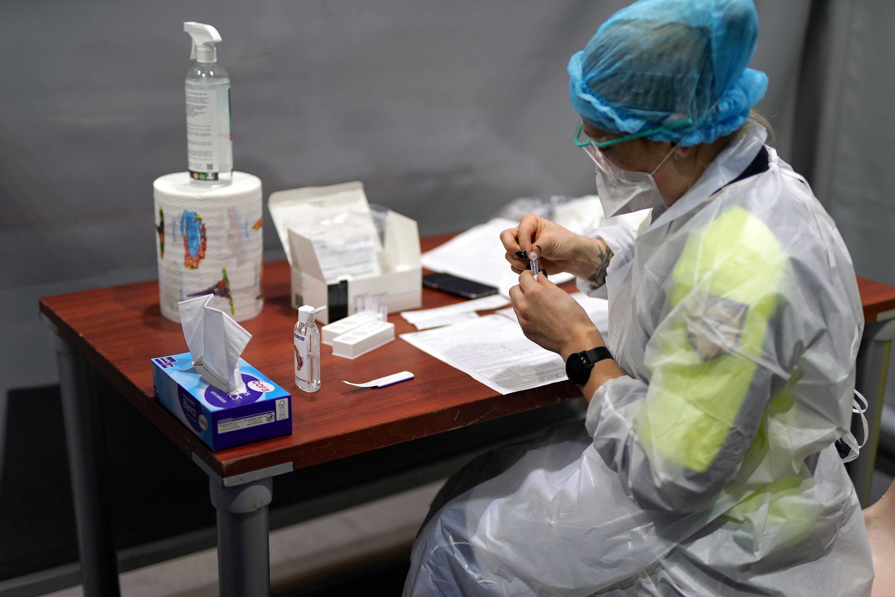 A medical worker handles a test tube after administering a nasal swab to a patient at a coronavirus testing center, on February 18, in Dunkirk, France, where the UK variant has been detected. 