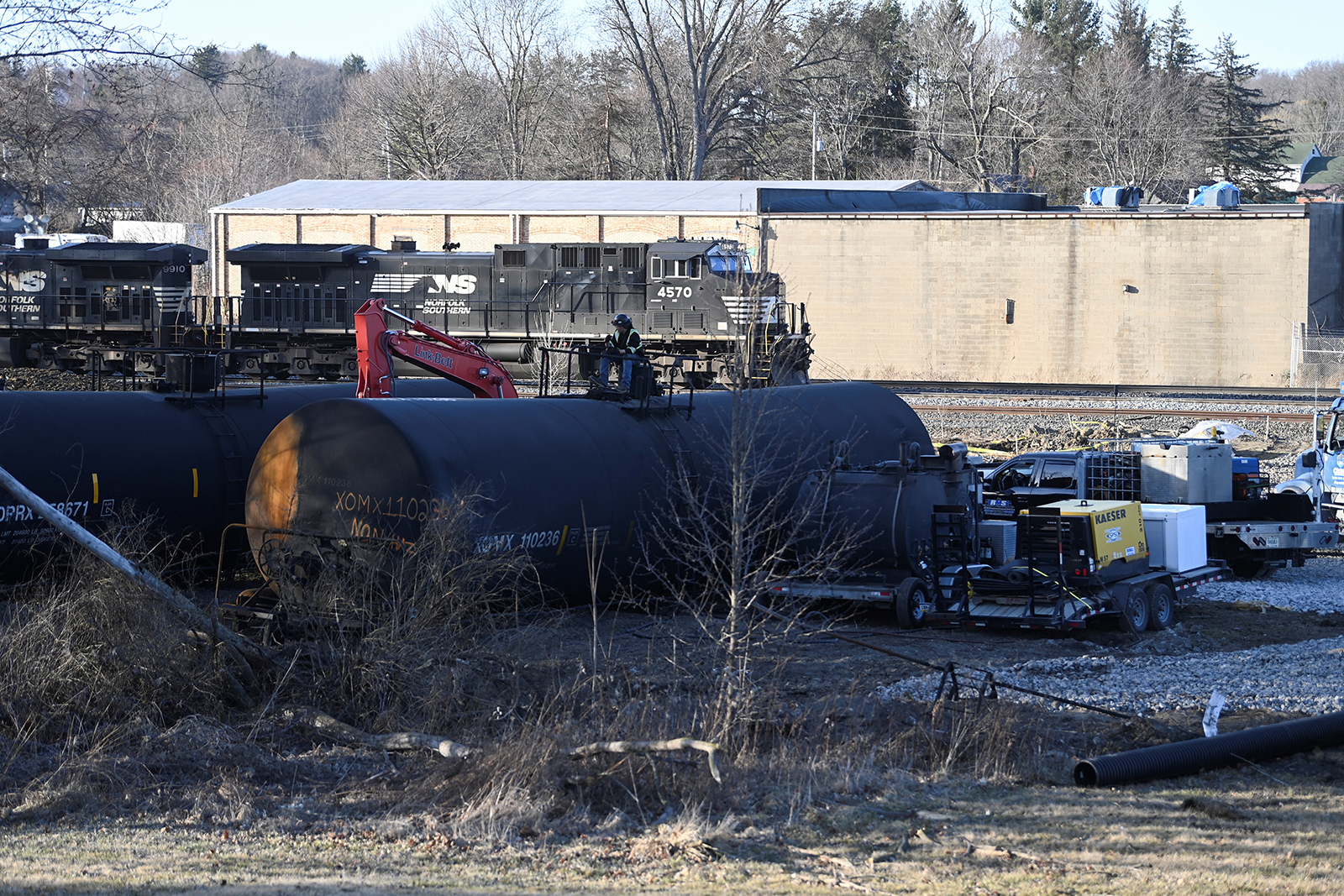 A worker sits on a container in East Palestine, Ohio, on February 15 at the site where toxic chemicals were spilled following a train derailment. 