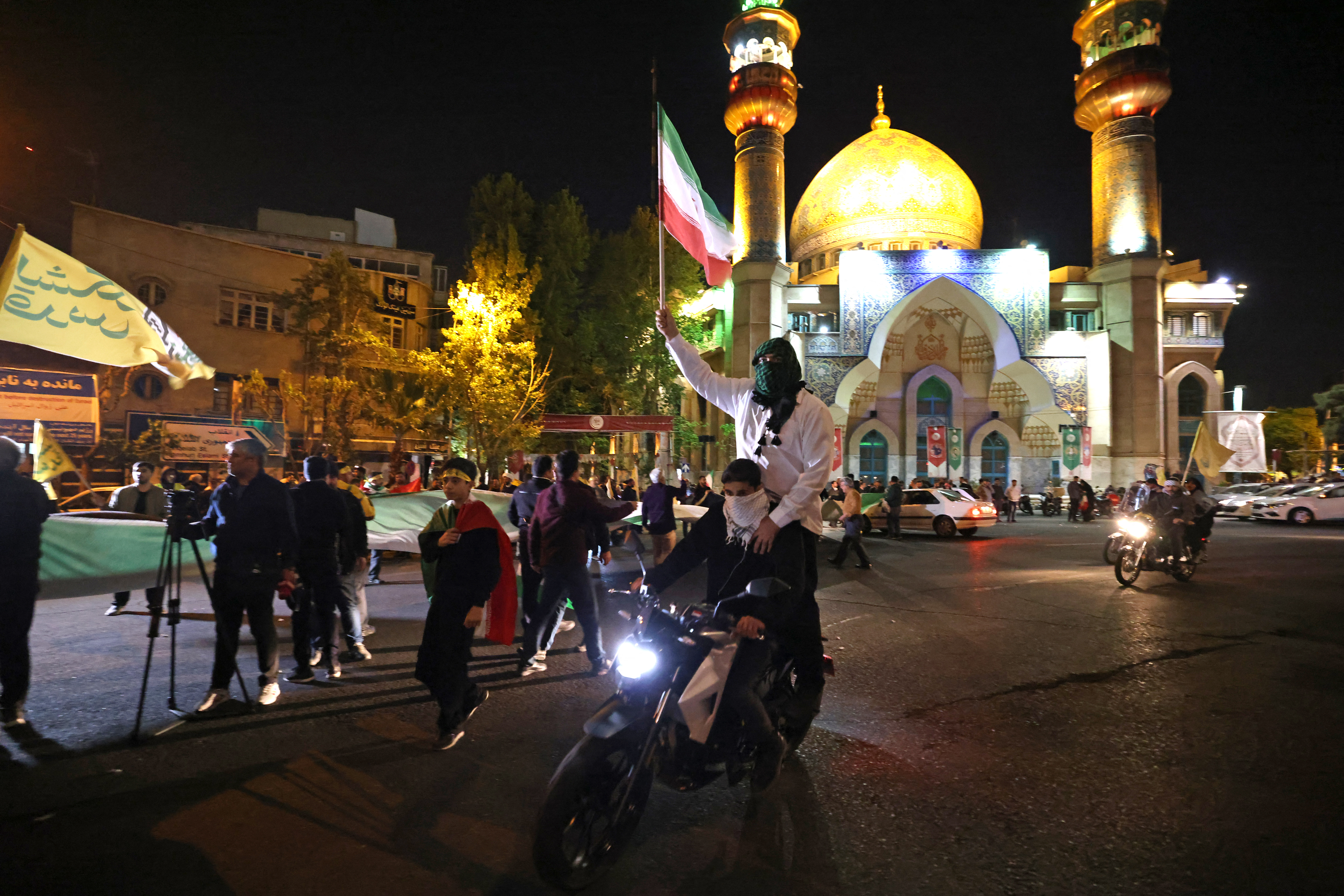 Demonstrators wave Iran's flag as they gather at Palestine Square in Tehran on April 14, after Iran launched a drone and missile attack on Israel.