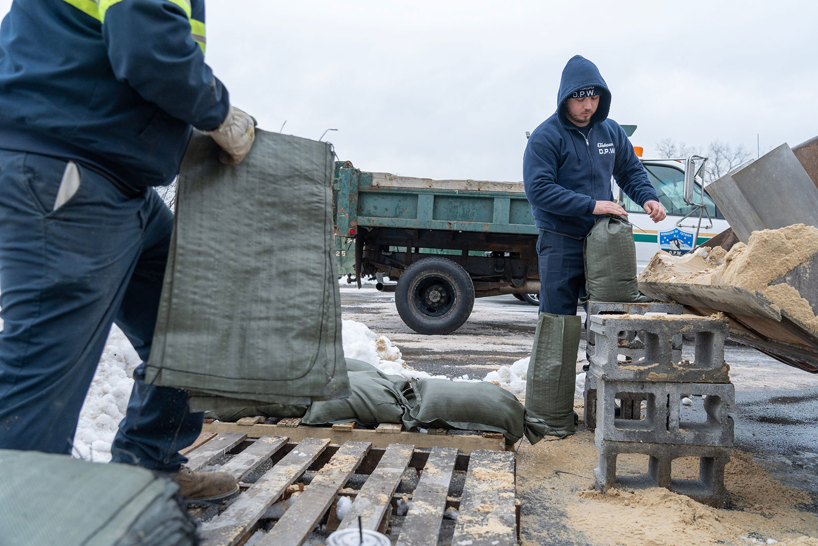 Totowa DPW workers from right, Brian Henderson and Josko Huljev, fill sandbags for residents of the township in Totowa, New Jersey, on Tuesday.