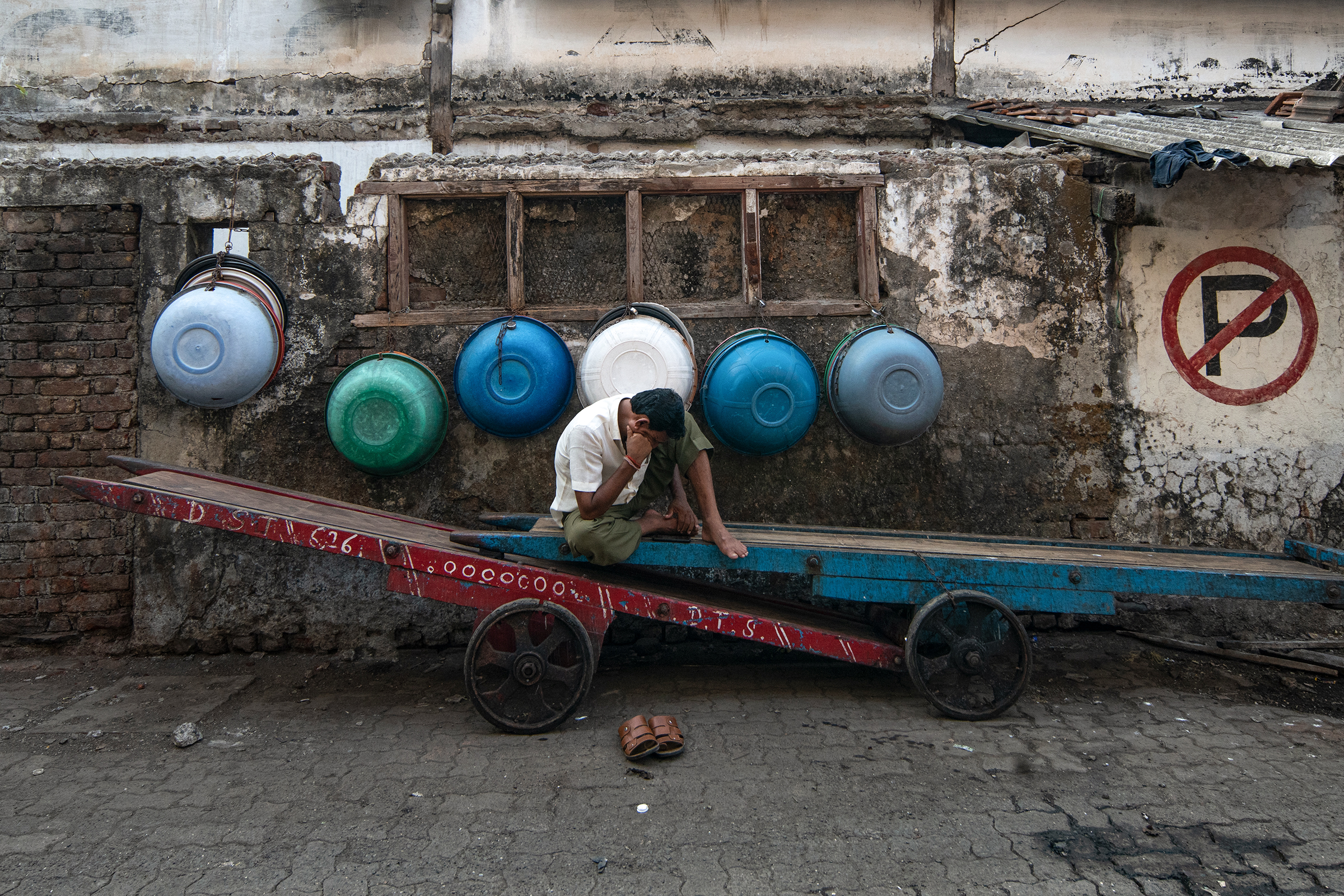 A worker watches his mobile phone while taking a break, in Mumbai on April 17.