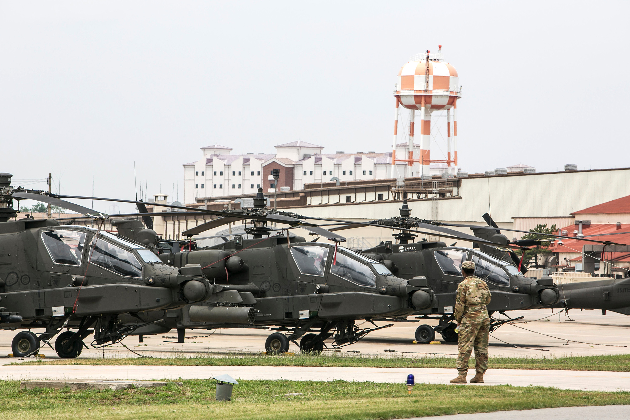 A member of the U.S. Army stands in front of military helicopters at U.S. Army Camp Humphreys  in Pyeongtaek, South Korea, on June 8, 2019. 
