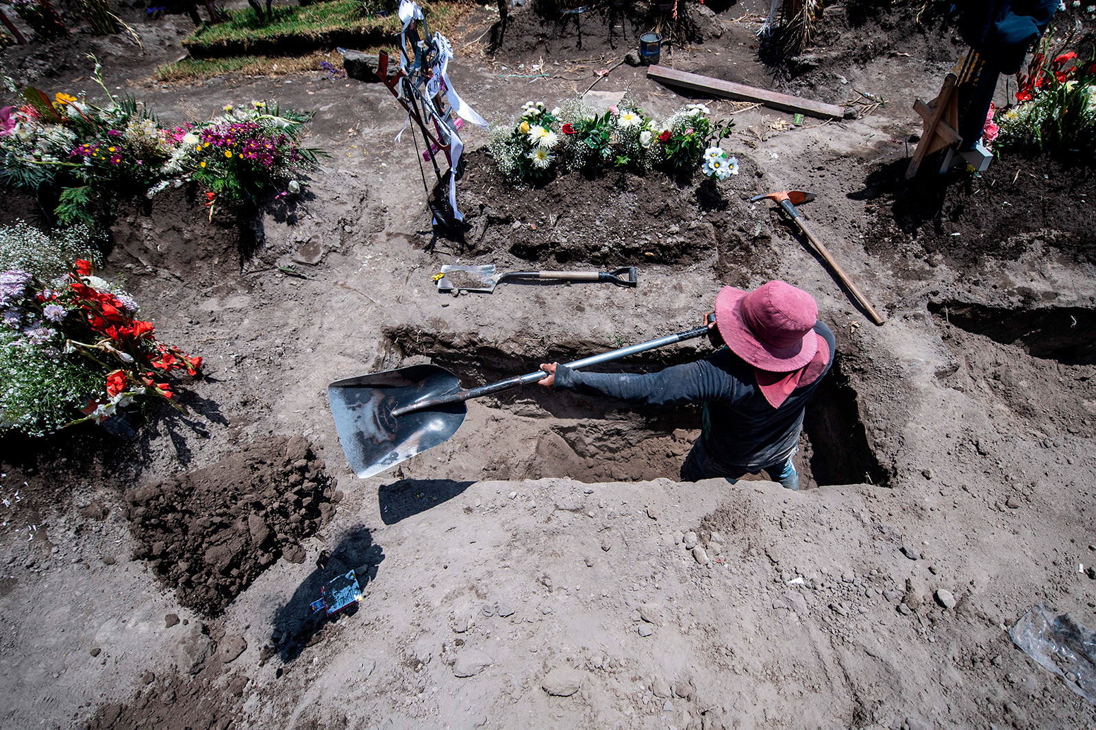 A gravedigger digs a grave during a funeral at the San Miguel Xico cemetery in Mexico on August 5.