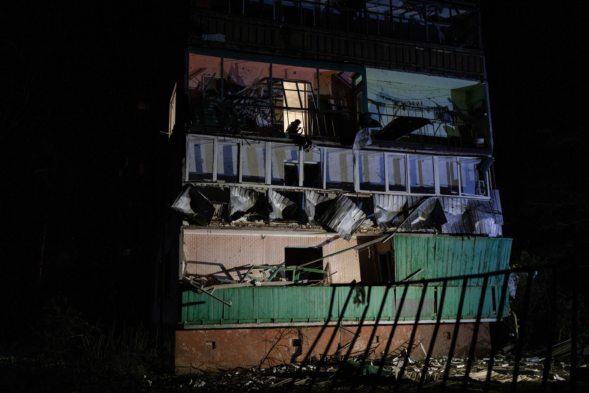 A resident in Sloviansk is seen clearing debris from his home in the damaged building following a rocket strike by the Russian forces on Thursday.