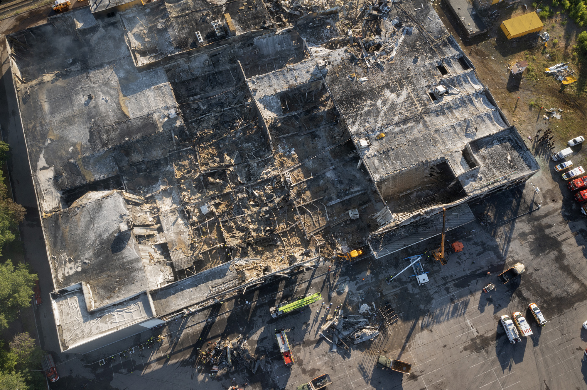 Ukrainian State Emergency Service firefighters work to take away debris at a shopping center after a rocket attack in Kremenchuk, Ukraine, on June 28.