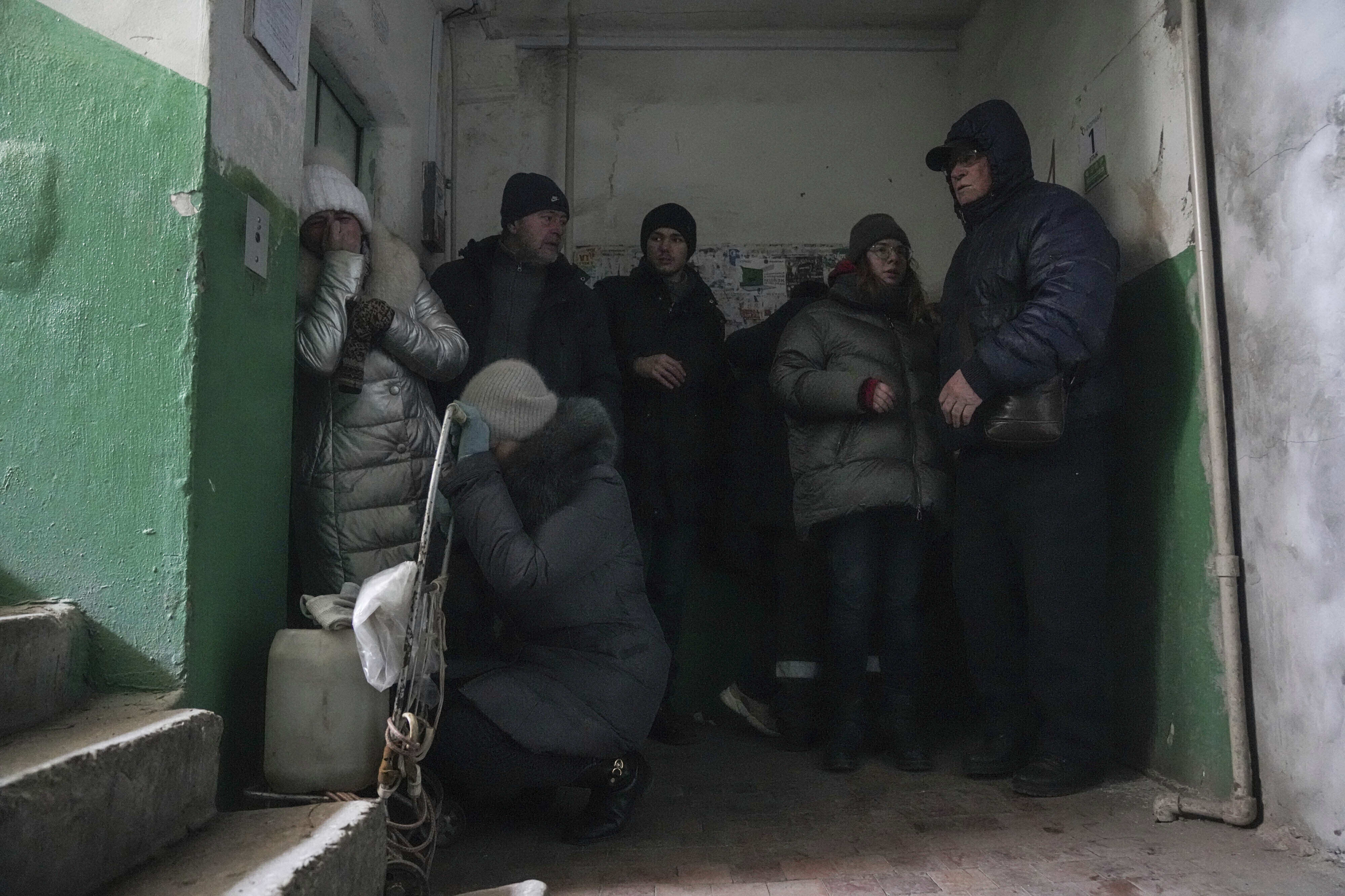 People take cover from shelling inside an entryway to an apartment building in Mariupol, Ukraine, on March 13.