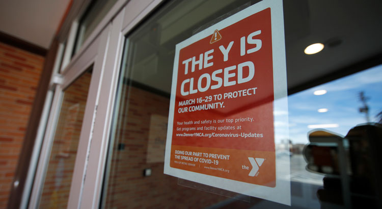 A sign hangs on the door to the Schlessmann YMCA as gyms have been forced to close in Colorado's efforts to fend off the spread of coronavirus Monday, March 16, in Denver.