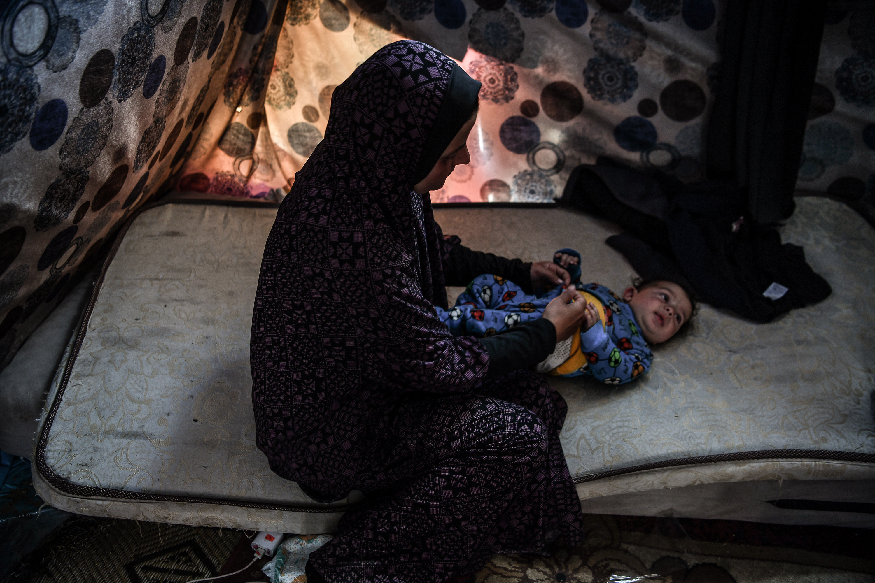 Feda al-Zahhar takes care of her 4-month-old baby as the family struggles to survive in a makeshift tent under difficult conditions on February 29. 