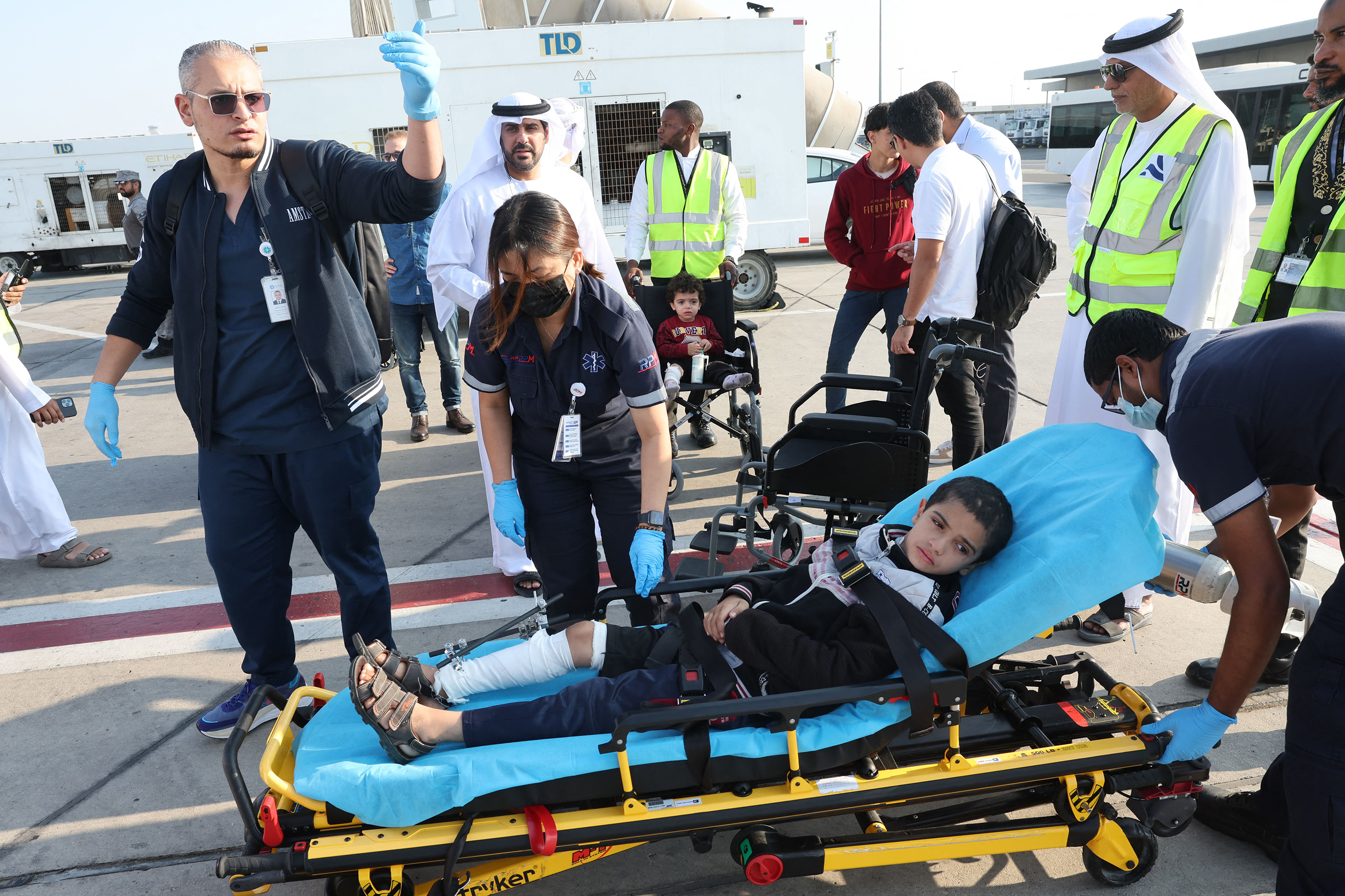 Volunteers transport a wounded Palestinian child off the plane upon their arrival in Abu Dhabi on November 18, after being evacuated from Gaza as part of a humanitarian mission organized by the United Arab Emirates. 
