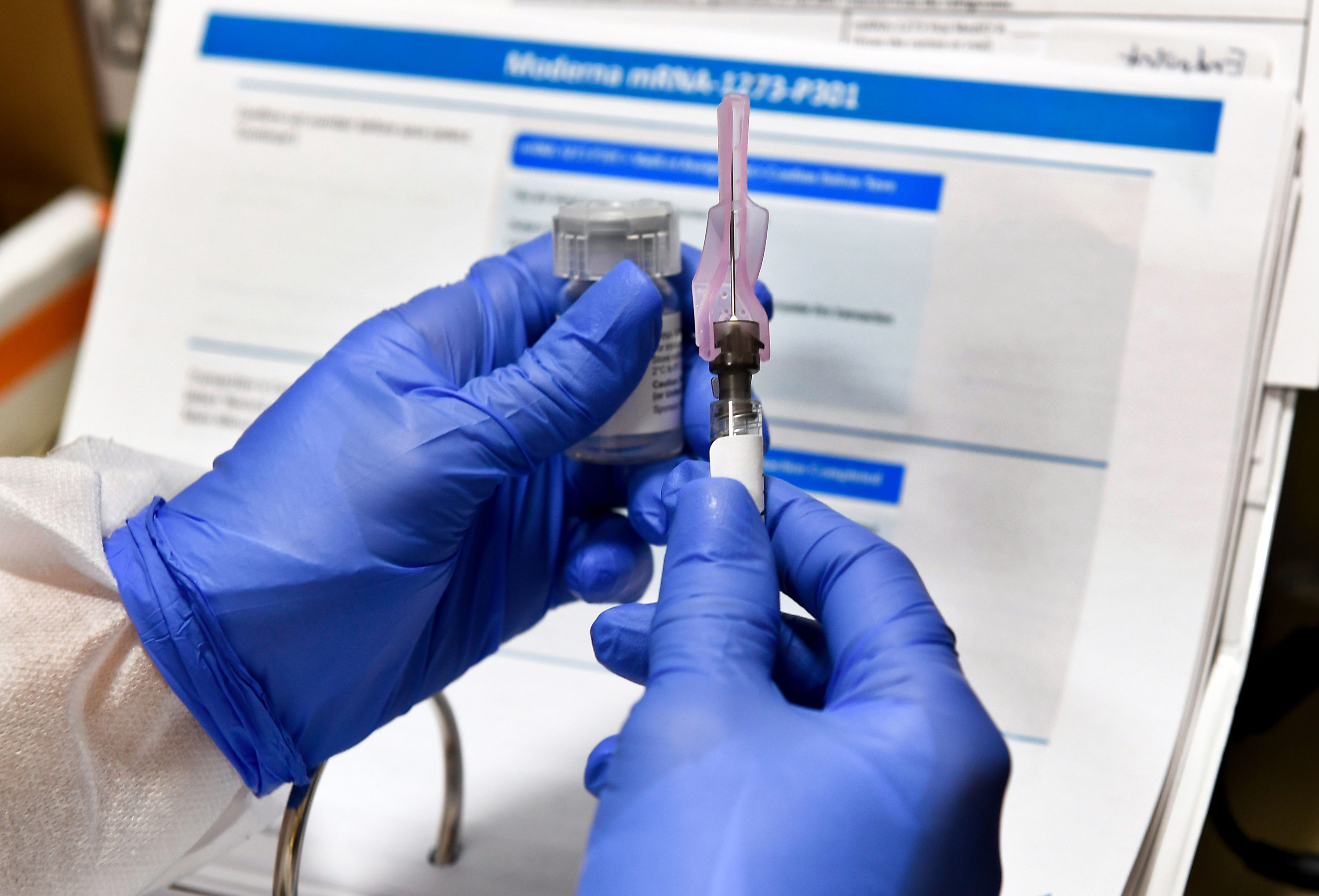 Nurse Kathe Olmstead prepares a shot that is part of a possible COVID-19 vaccine, developed by the National Institutes of Health and Moderna Inc., in Binghamton, New York, on July 27. 