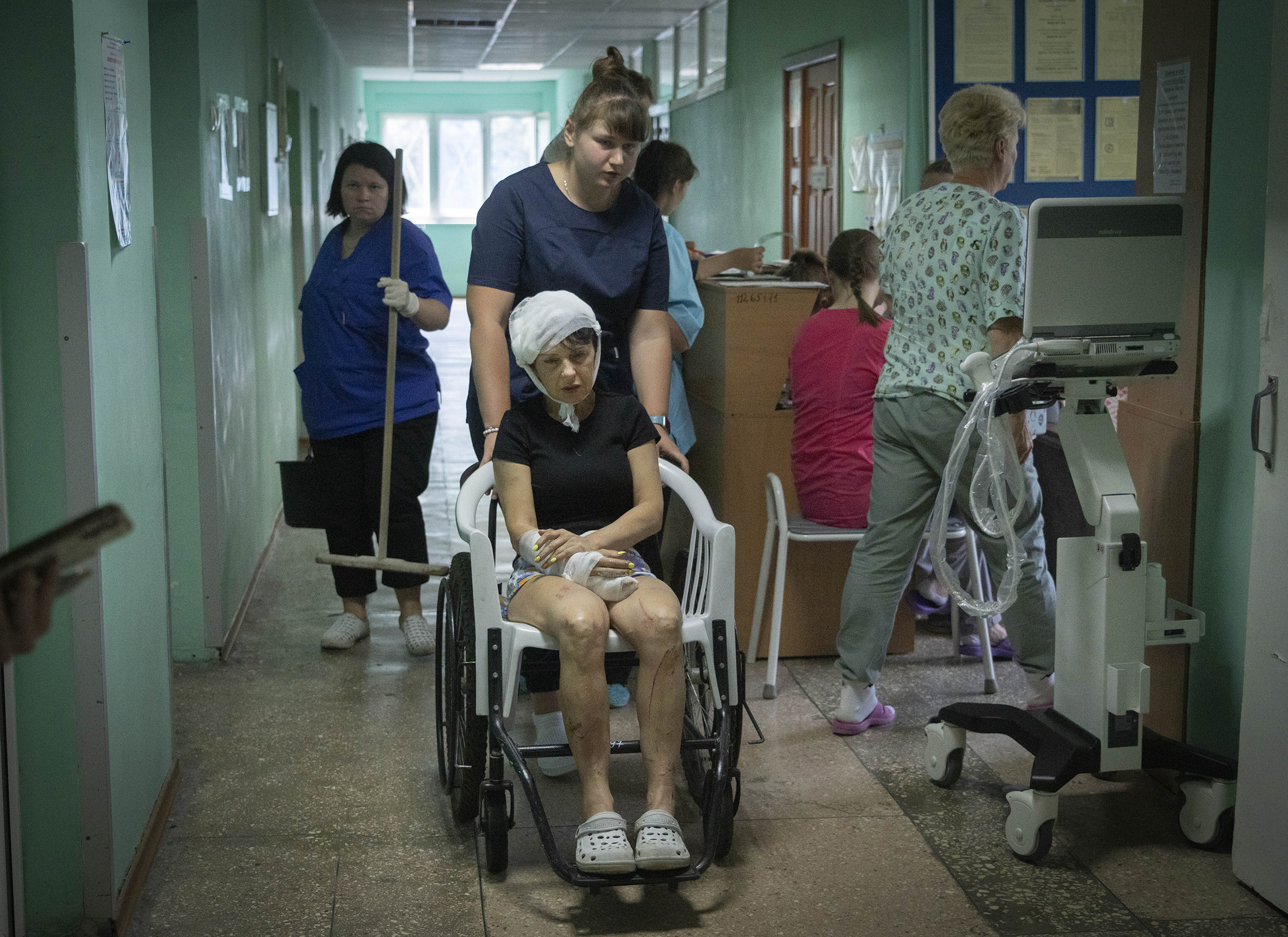A hospital nurse pushes a wheelchair containing a woman injured by the Russian missile attack on a shopping center in Ukraine's Kremenchuk on June 28.