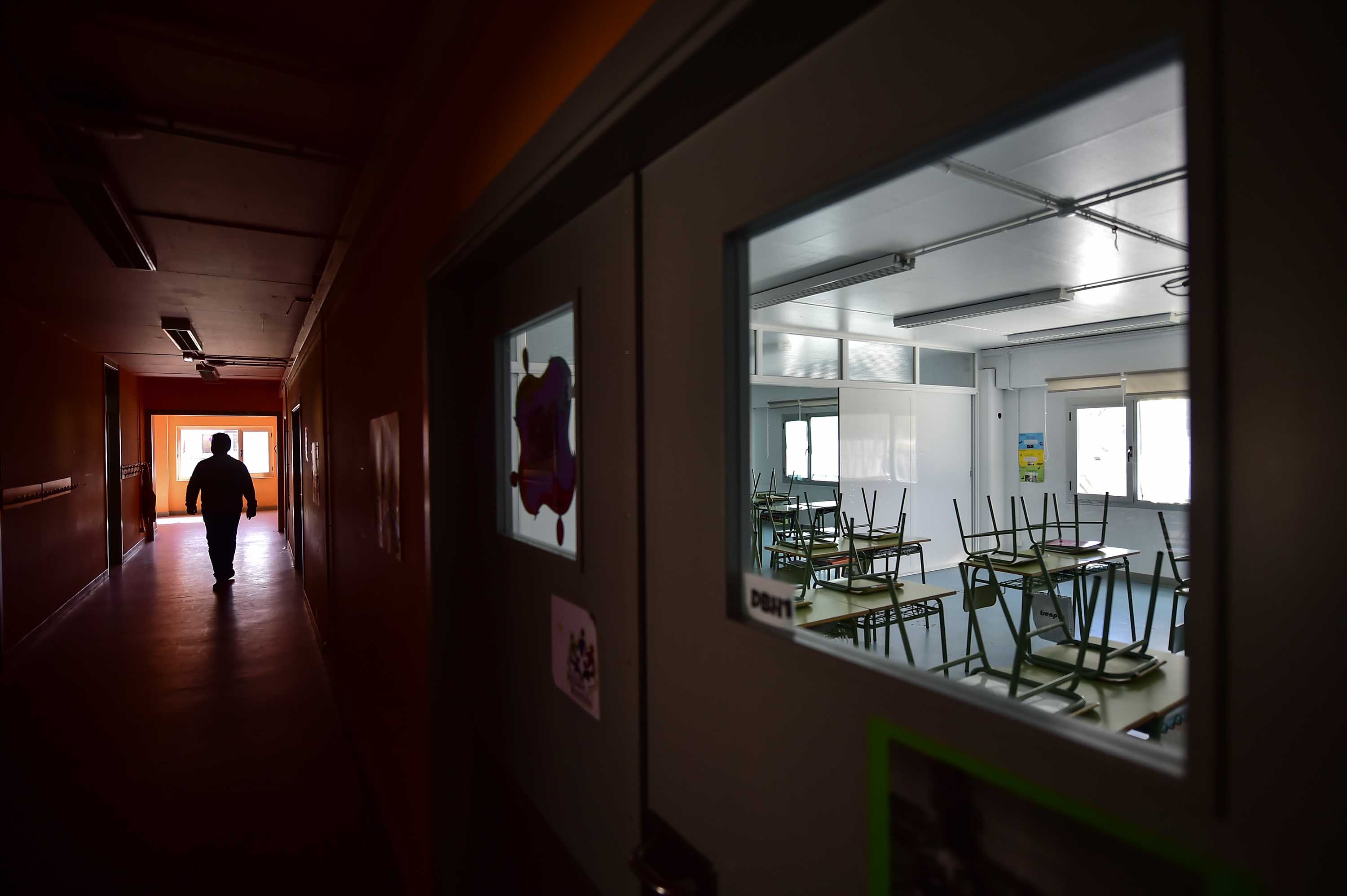 A teacher walks along a hallway of an empty public school in the village of Labastida, in northern Spain, on Wednesday, March 11.