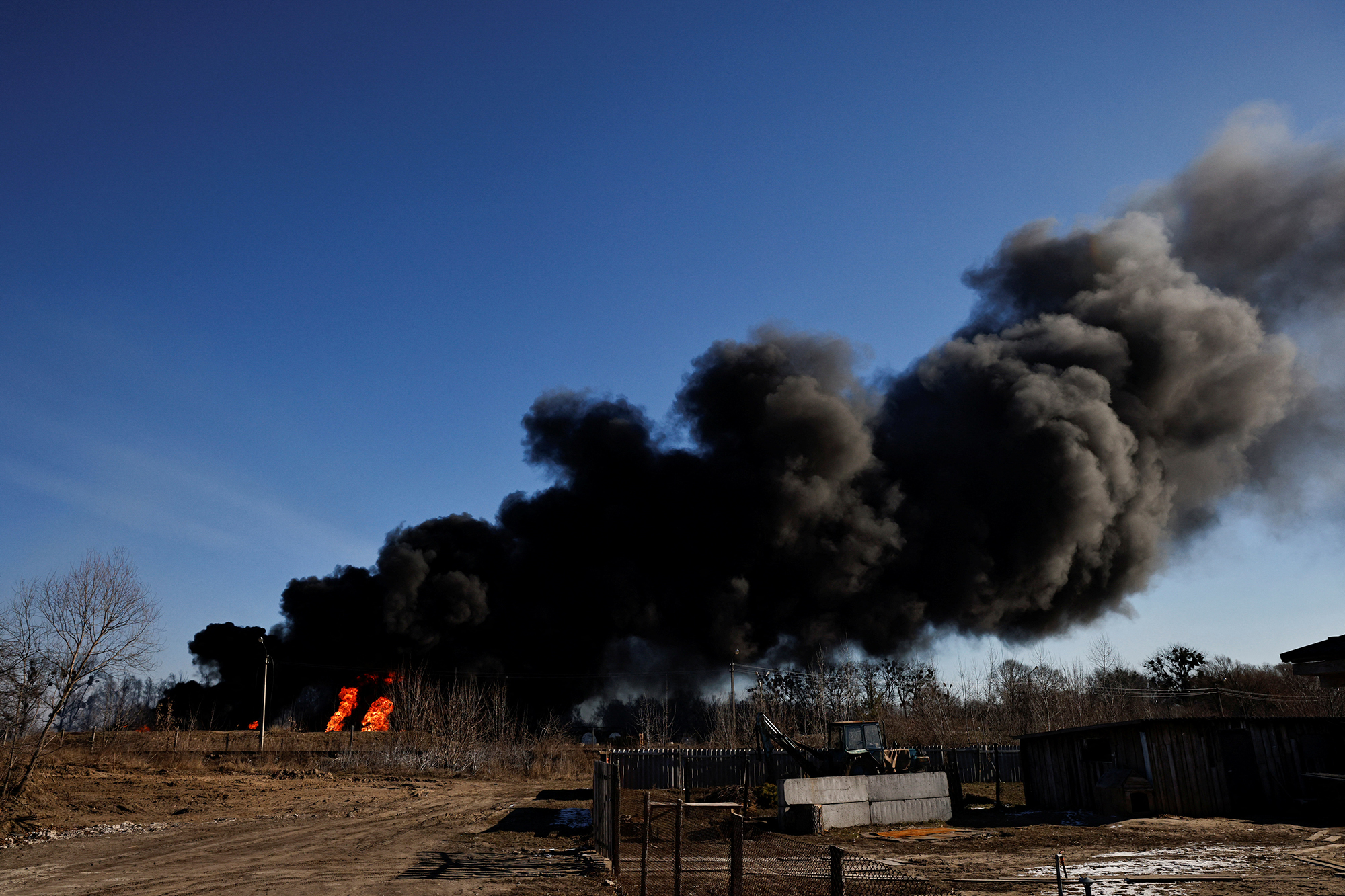 A column of smoke rises from burning fuel tanks at an air base in Vasylkiv, Ukraine on March 12. 
