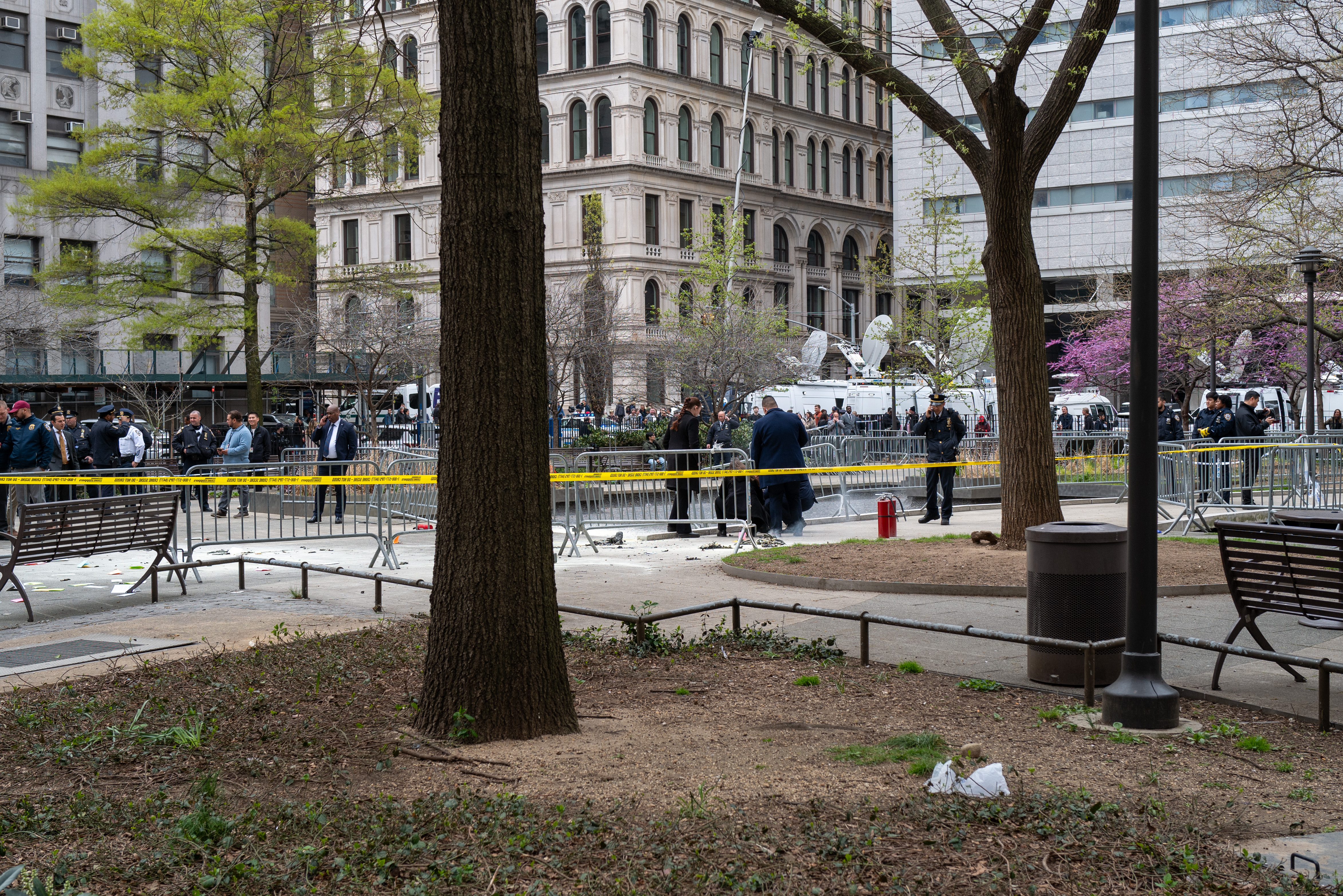 Police and emergency officials gather in a park near the Manhattan Criminal Courthouse in New York, where a man lit himself on fire, on April 19.