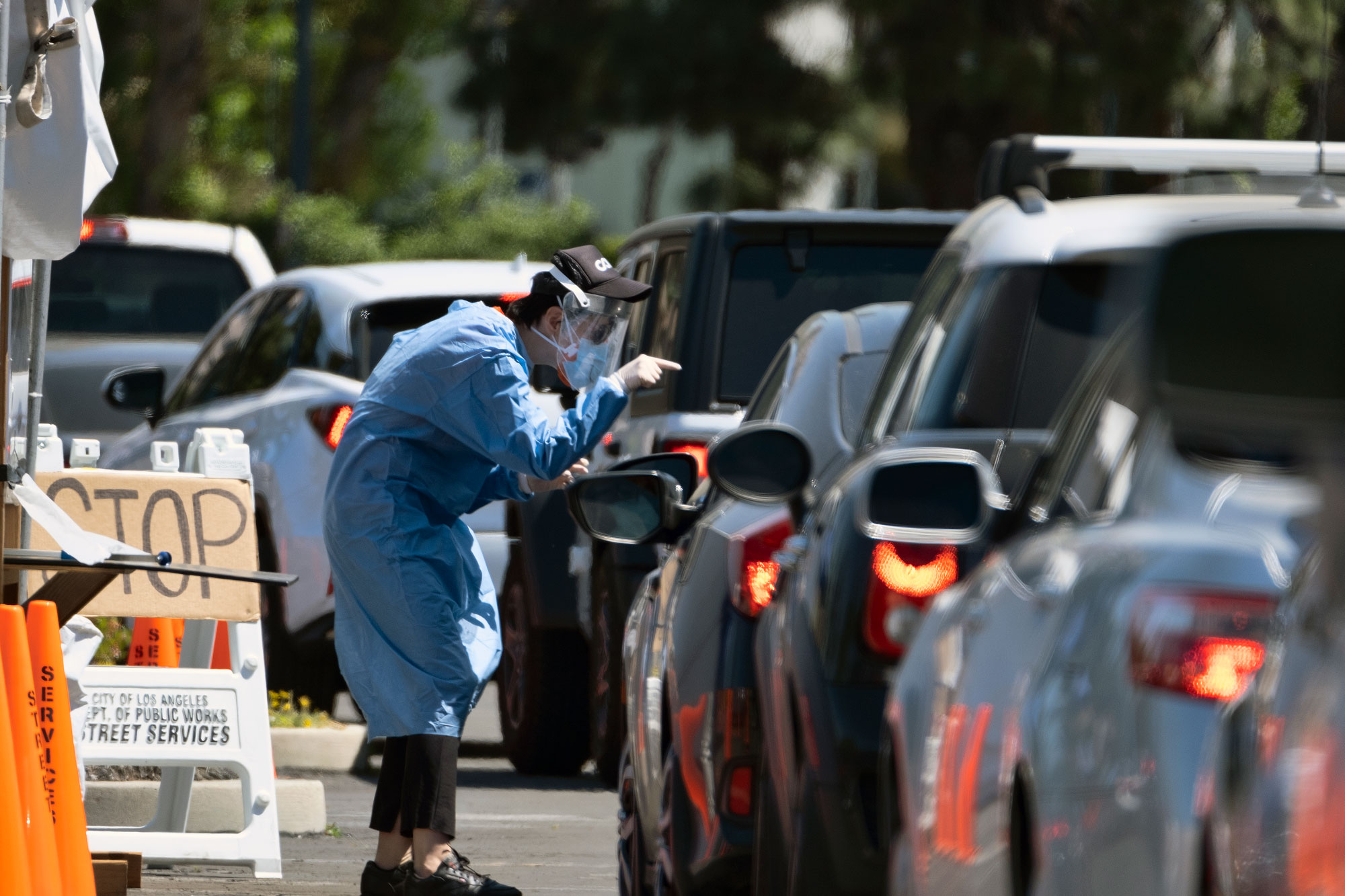 A  Community Organized Relief Effort volunteer directs cars lining up for coronavirus testing in Los Angeles on May 2.