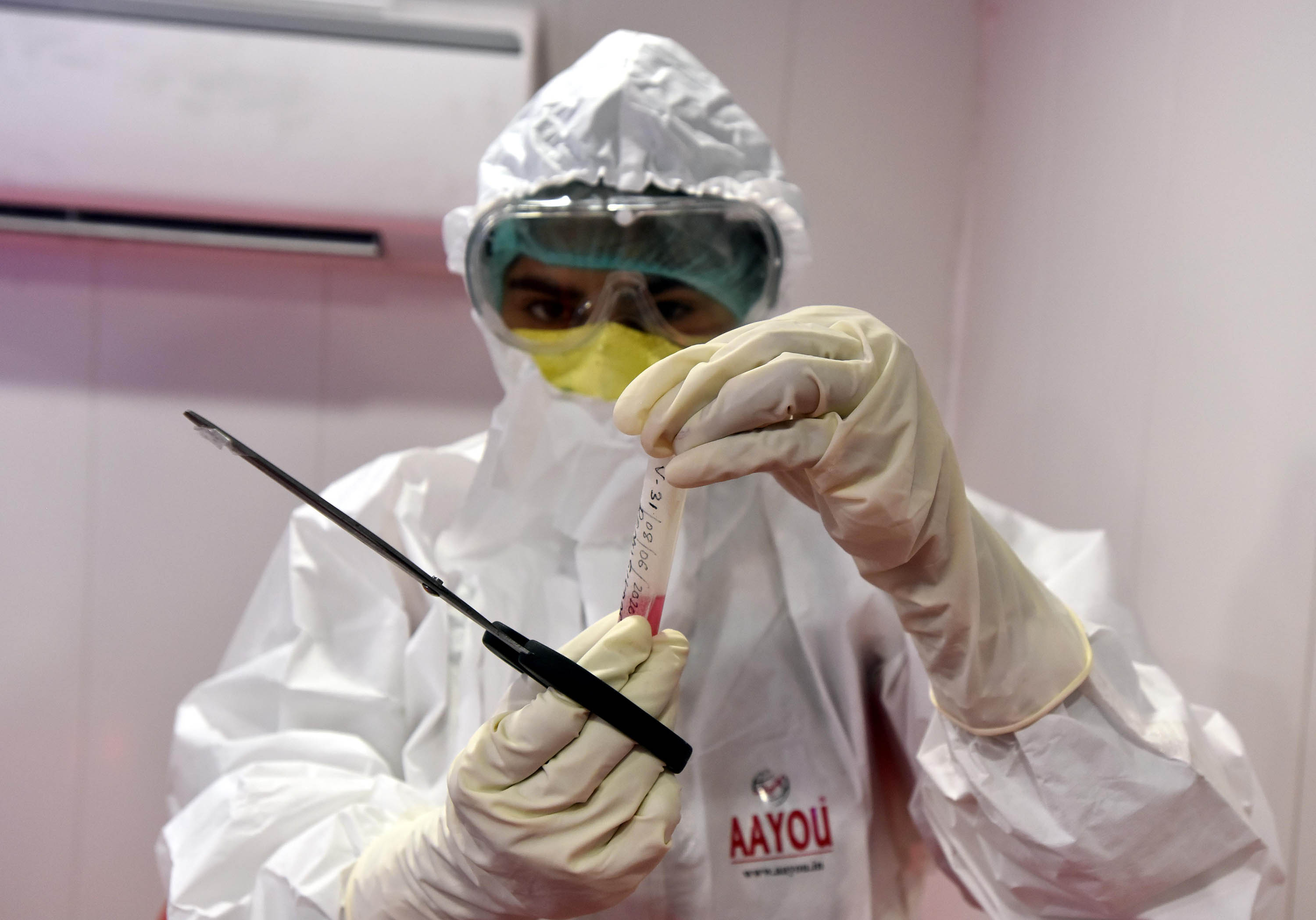 A medical worker handles a sample collected for coronavirus testing inside a mobile clinic in New Delhi, India, on June 8.