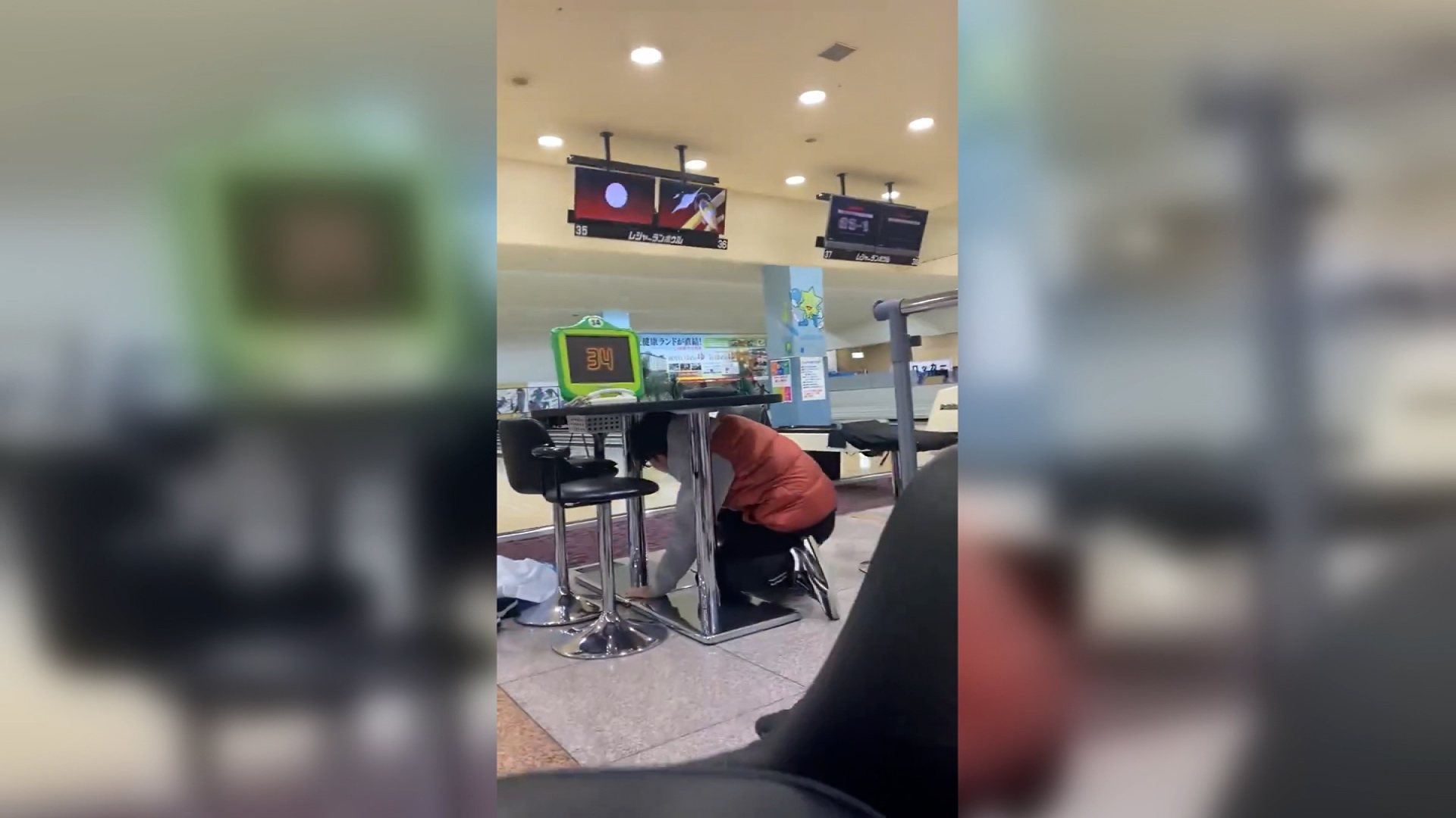 A person is seen hiding under a table at a bowling alley during the earthquake in Japan's Ishikawa Prefecture, in this screengrab taken from a video posted to social media.
