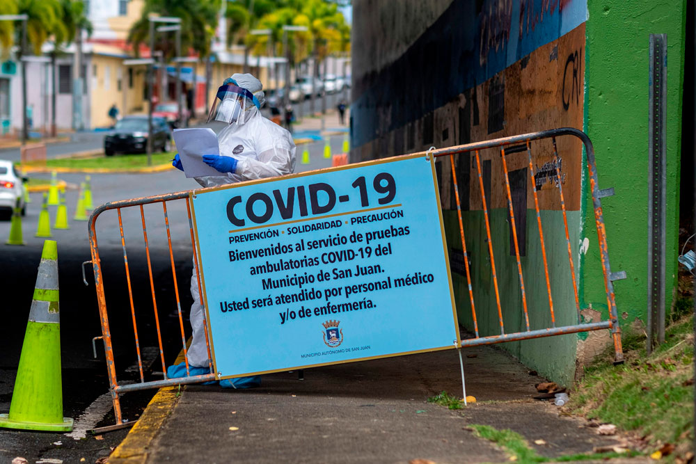 A medical personnel stands at the entrance of a municipal Covid-19 drive-thru testing site in San Juan, Puerto Rico, on March 25. 