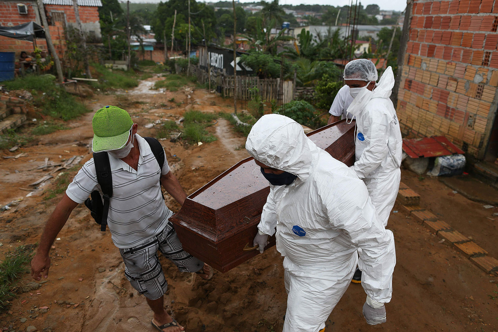 Workers remove a body from a home in Manaus, Brazil, on May 4.
